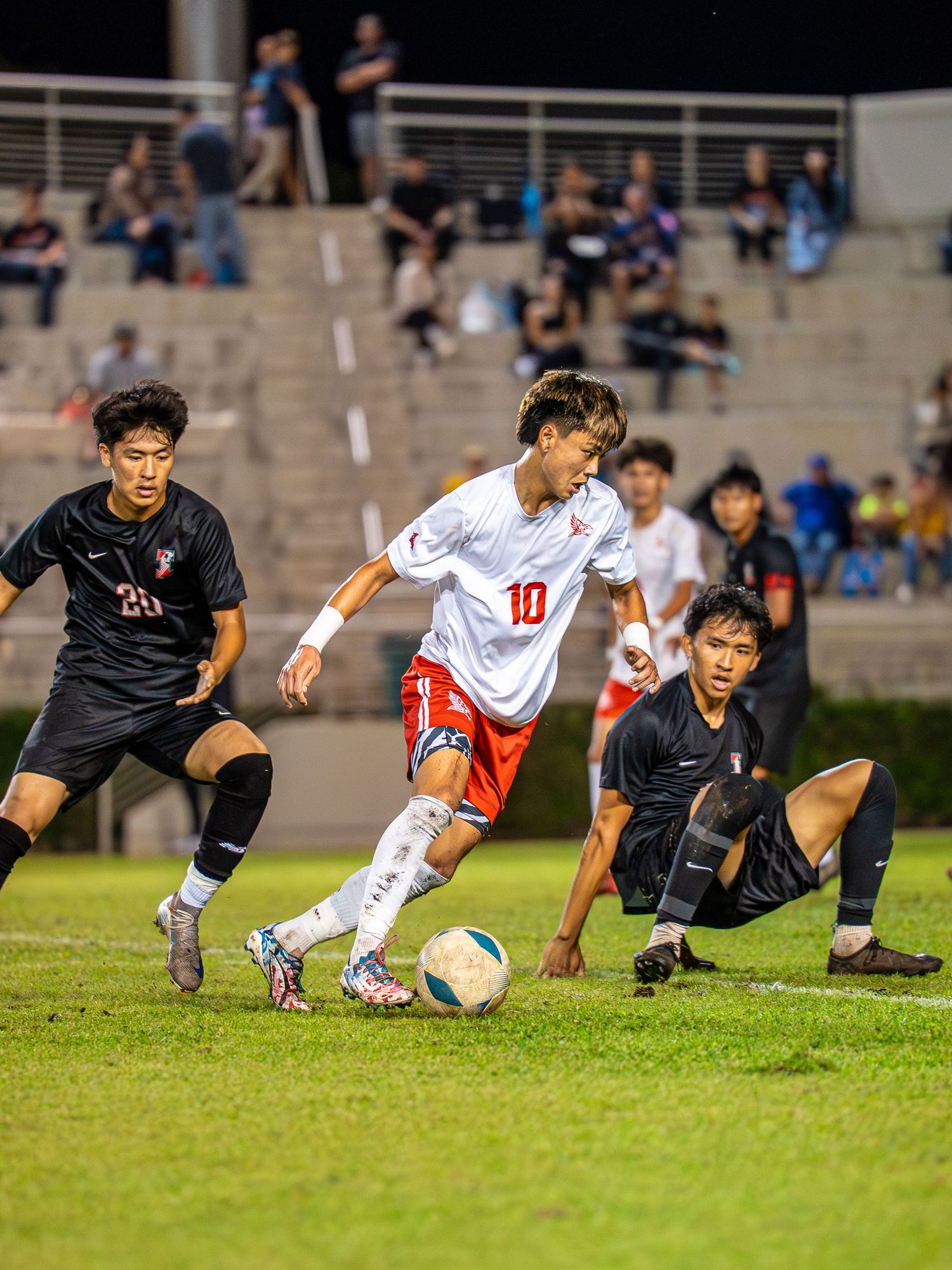 College soccer player sprinting with the ball on a Hawaii field