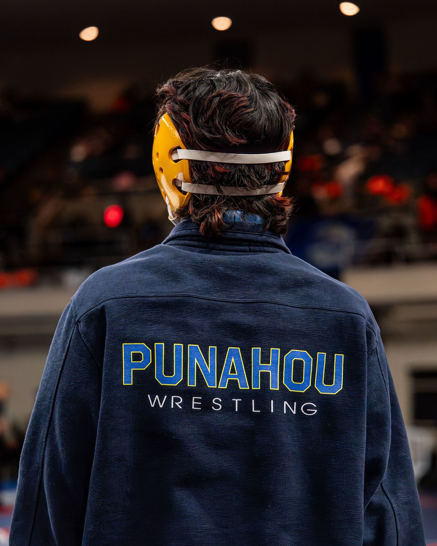 Wrestler executing a takedown during a Hawaii championship bout