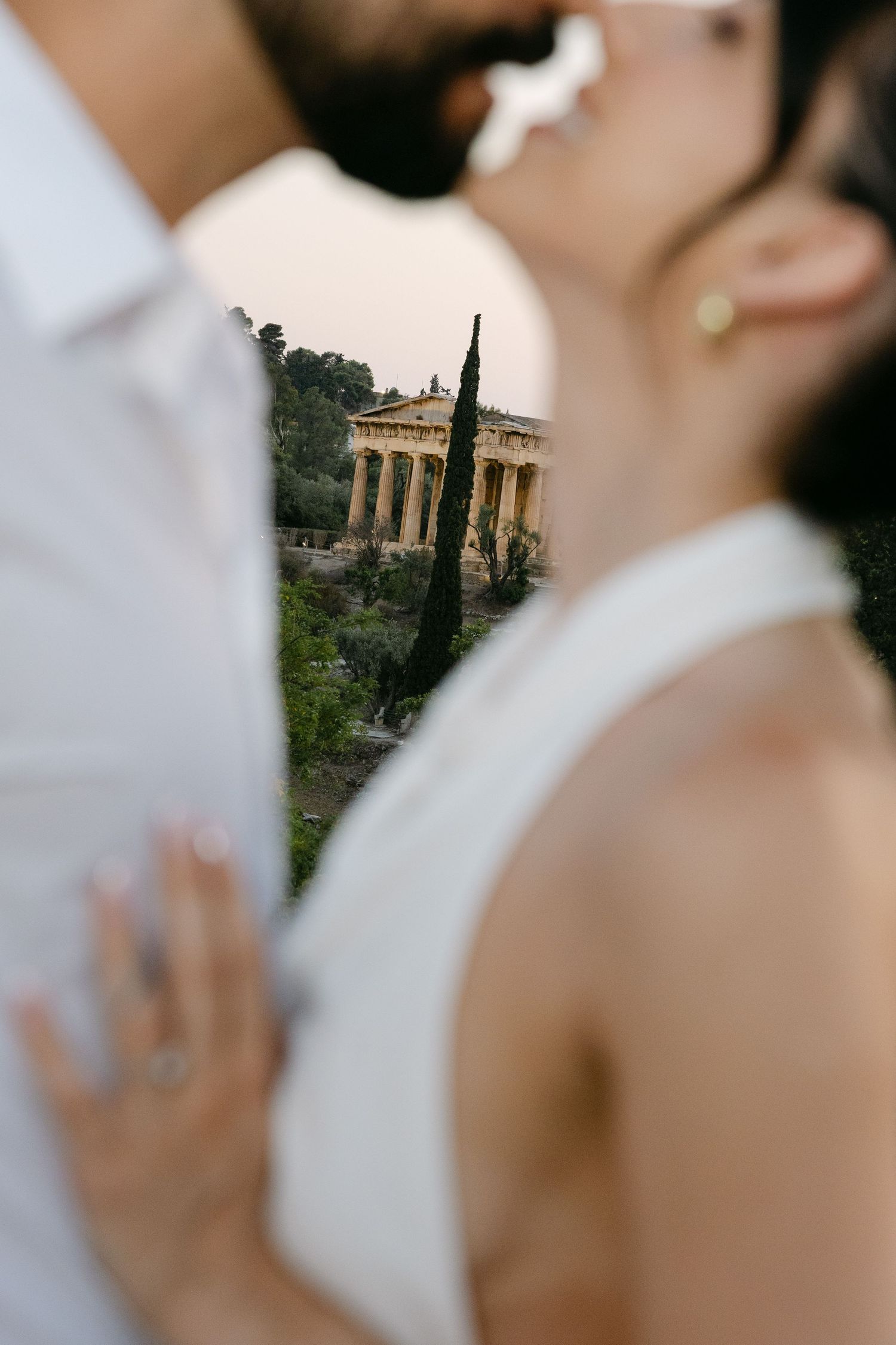 A romantic couple embraces in front of ancient Roman ruins during a wedding photo session.