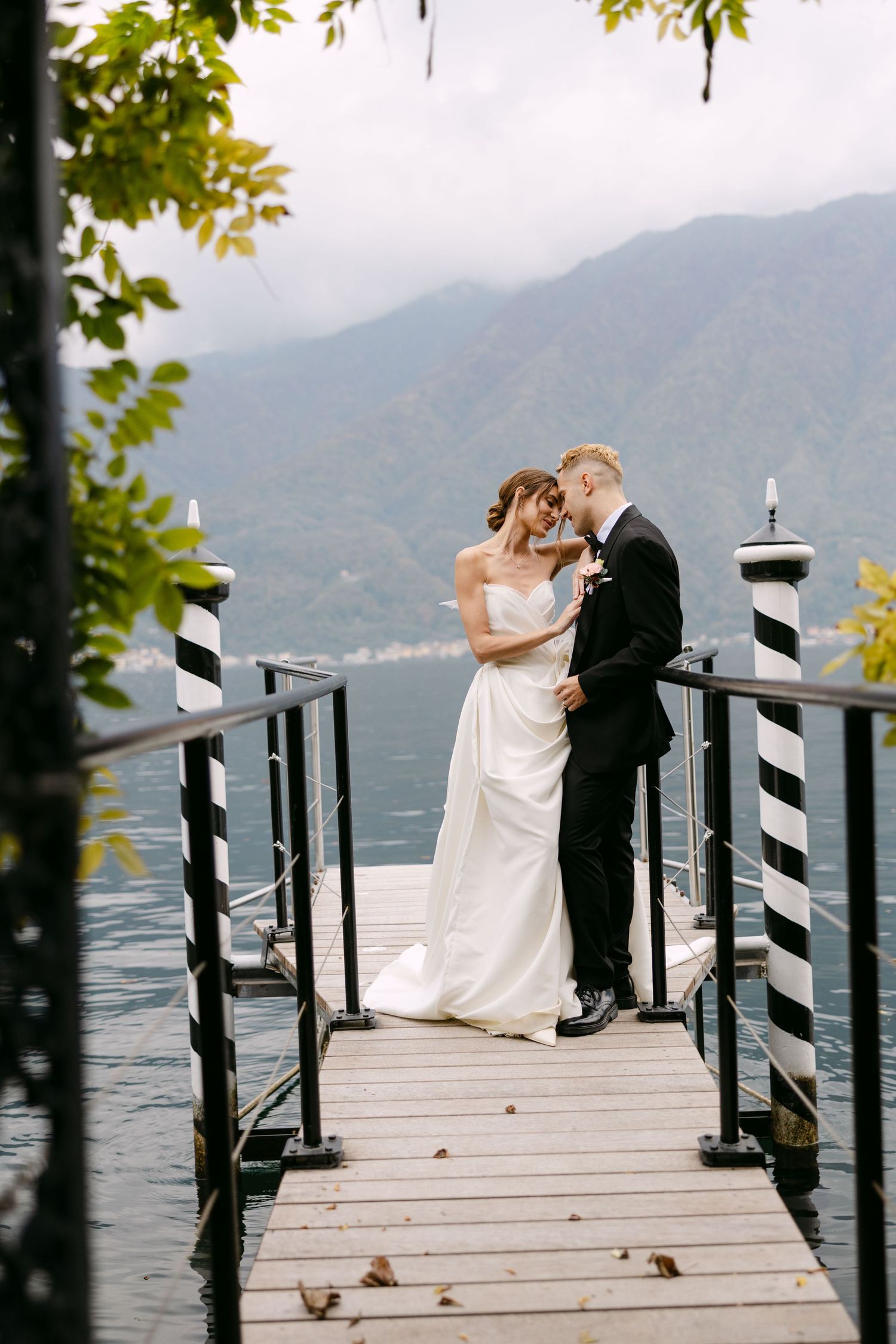 couple on their wedding day on a dock in lake como