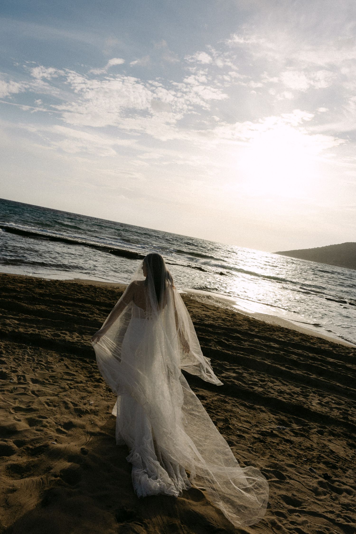Aethereal bride with editorial vibes walking in the sunset by the sea