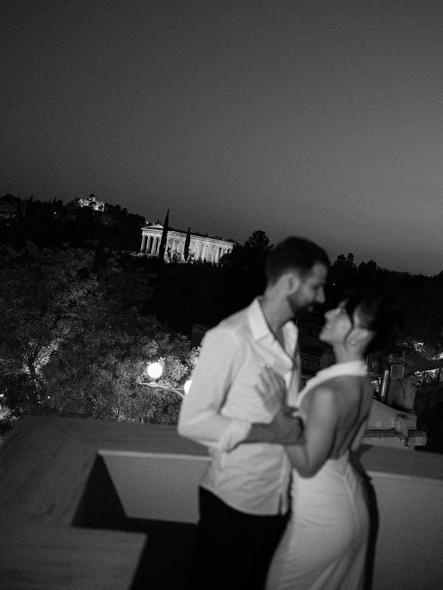 A romantic black and white photo sequence shows a couple sharing a tender kiss at sunset outdoors.