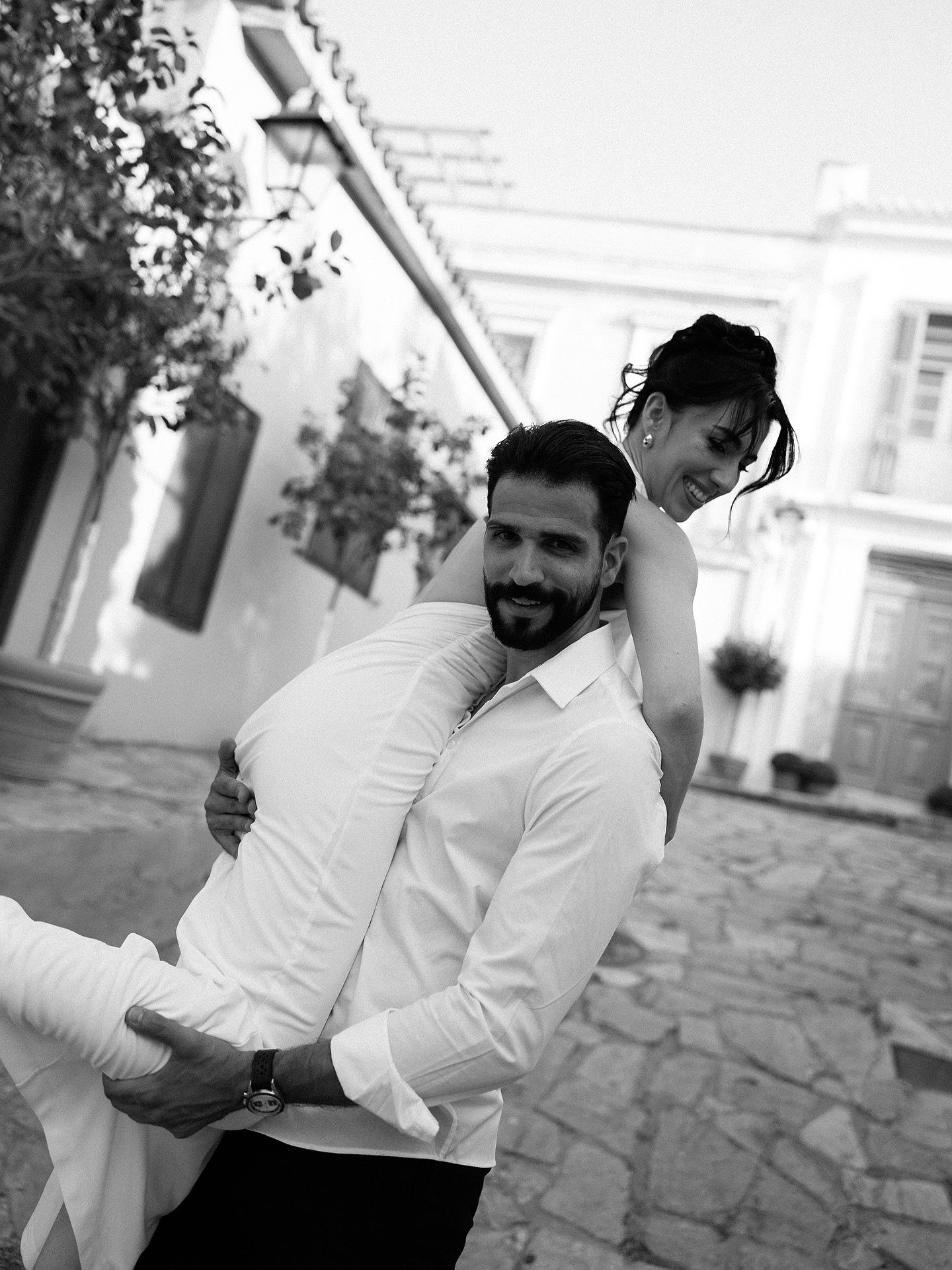 Black and white sequence of candid moments showing joyful expressions and casual interactions on a stone paved patio.