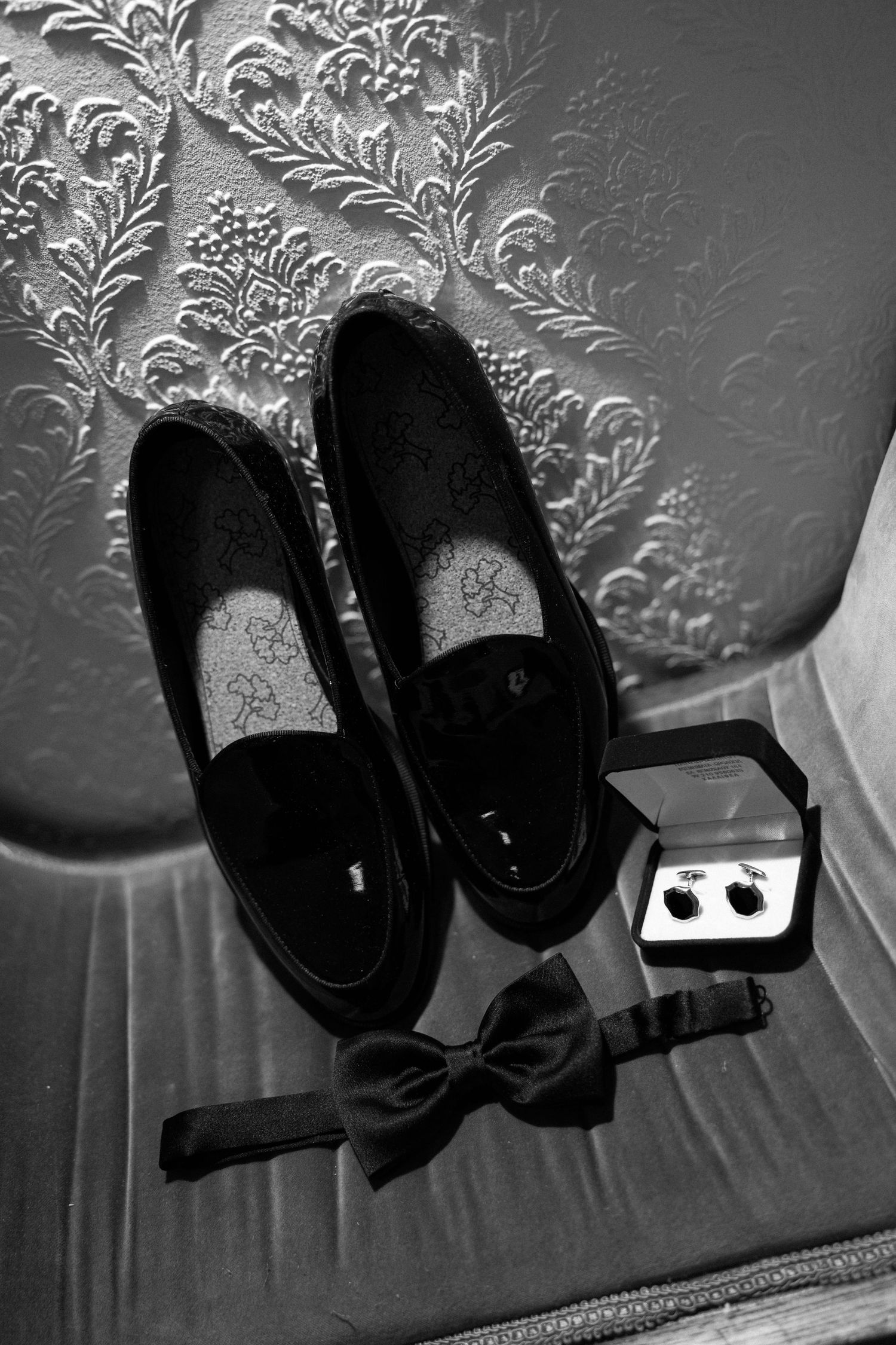 Black and white image series showing stage spotlights mounted against a decorative wallpaper background.