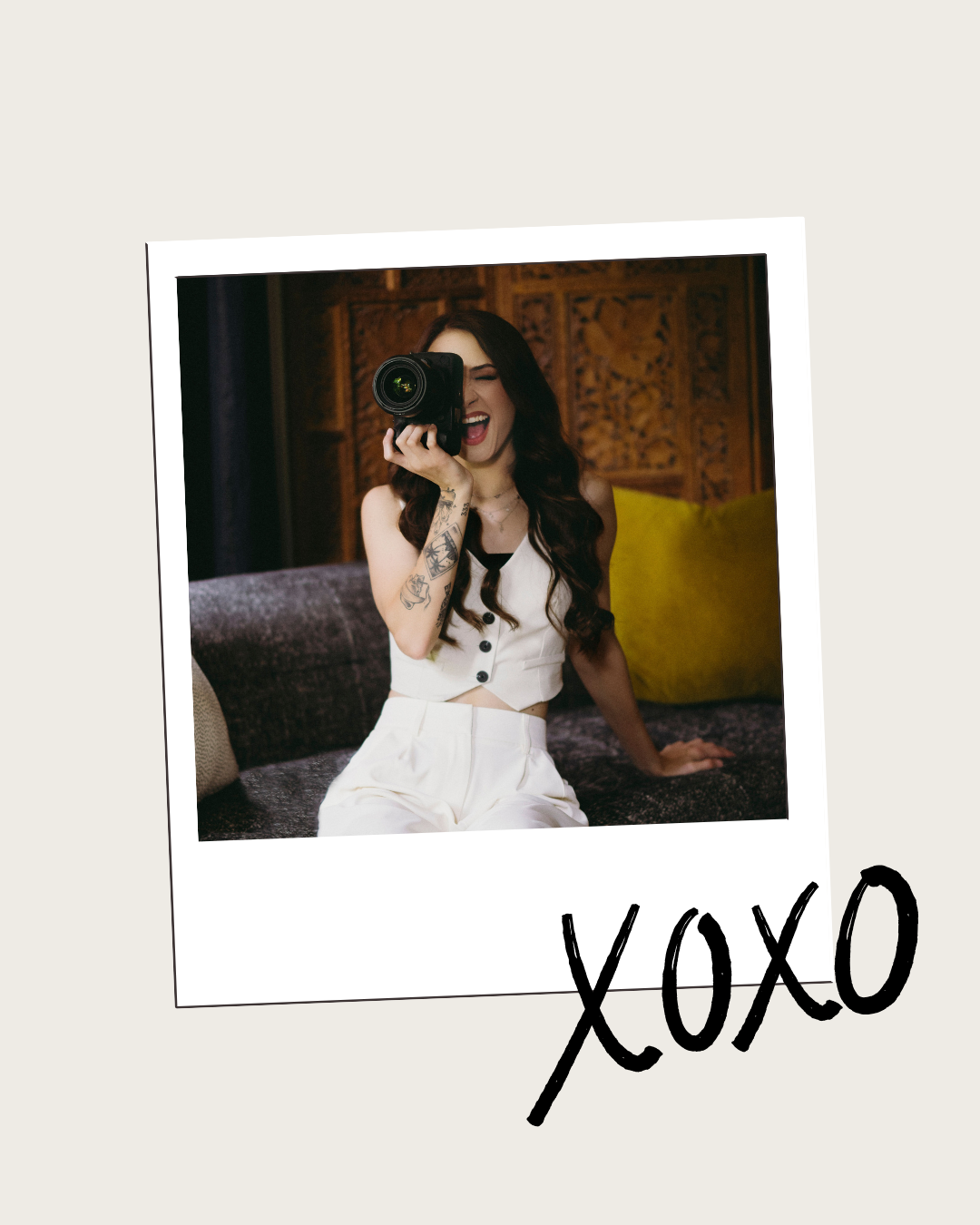Woman holding camera in polaroid photo with XOXO text on cream background.