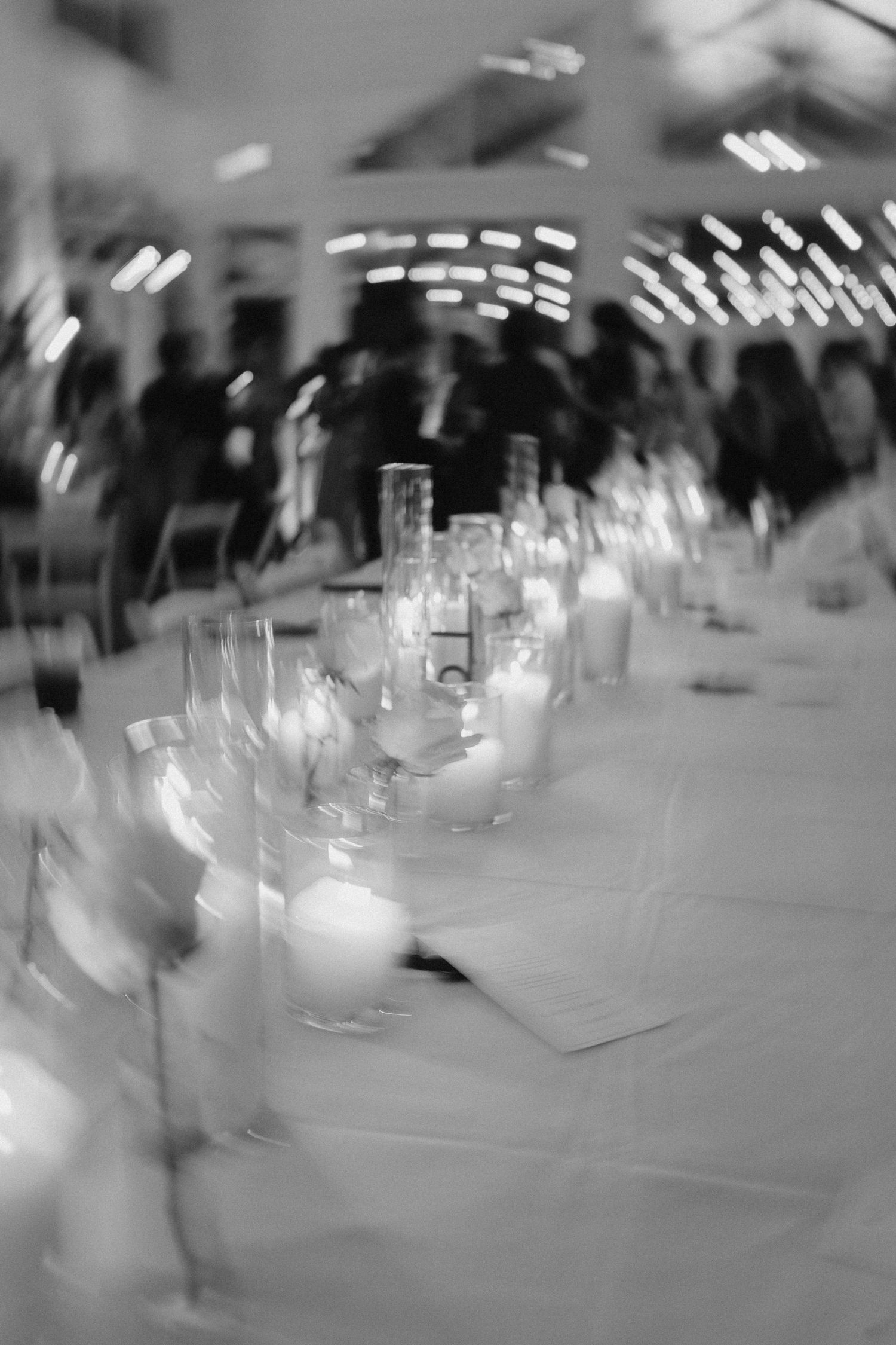 Blurred black and white photo of elegant candlelit wedding reception table setting.