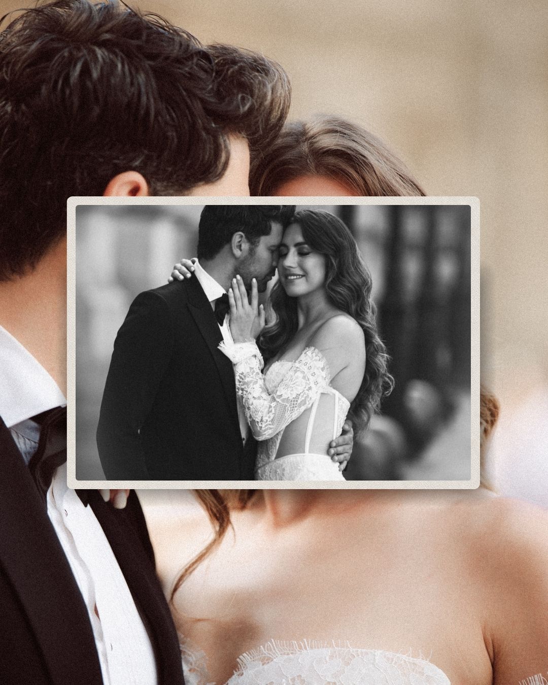 Black and white wedding photo of smiling bride in lace dress embracing groom in tuxedo.