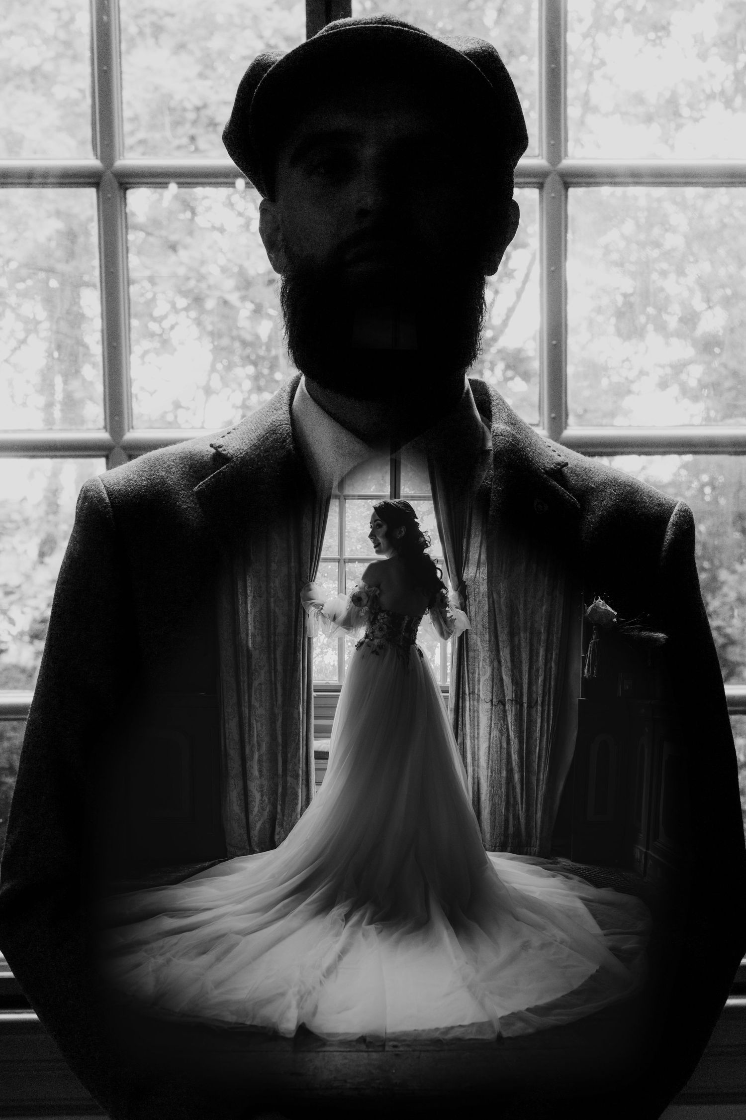 Creative black and white double exposure of a groom and bride in a wedding dress by a window.