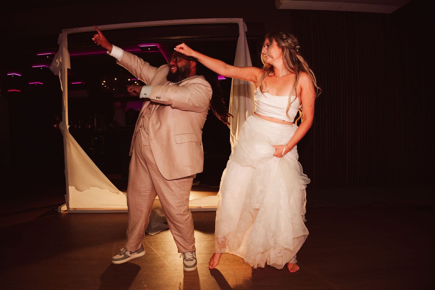 Bride and groom dancing joyfully at their wedding reception.
