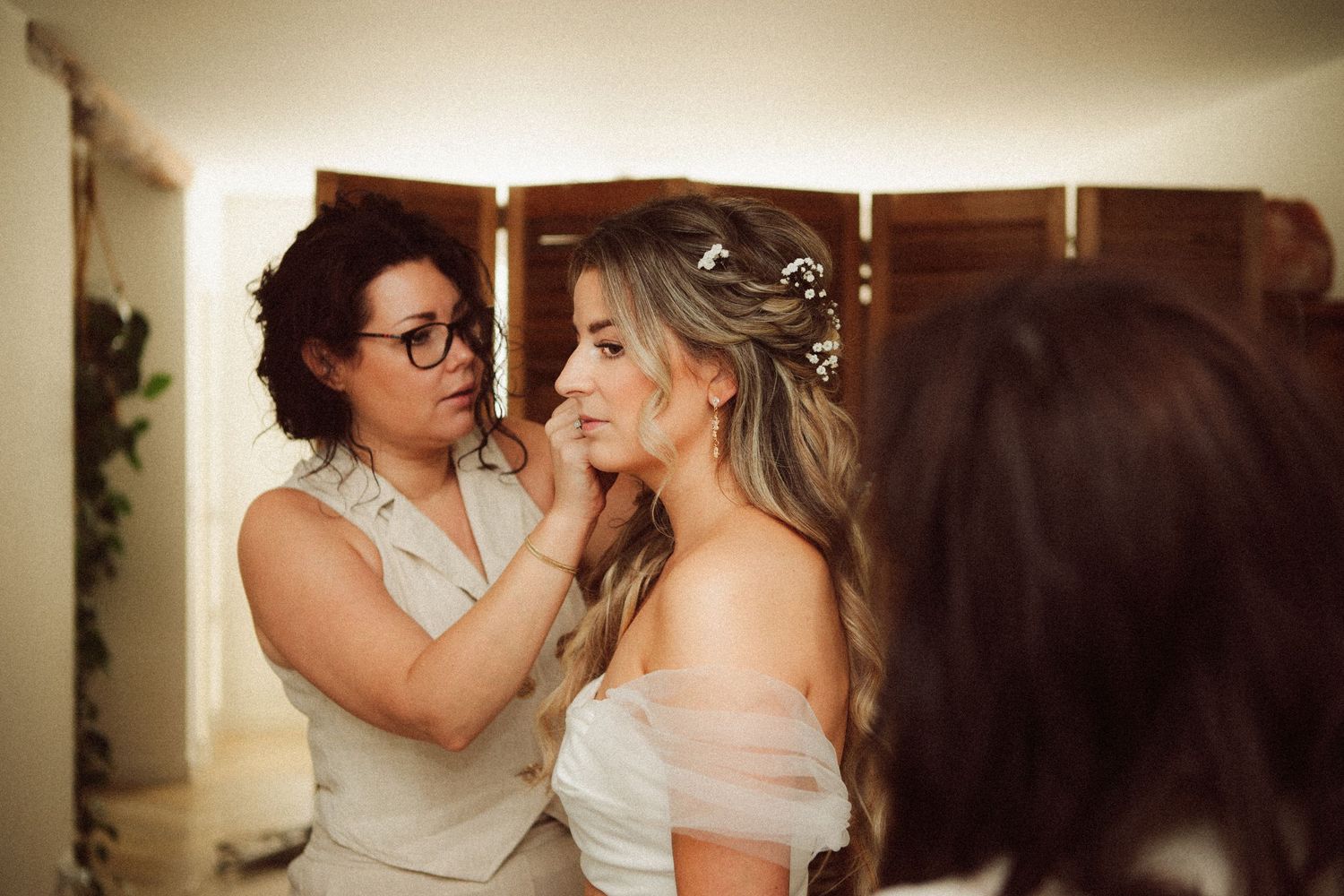 Wedding hairstylist adjusting the brides hair accessories as she prepares for her ceremony.