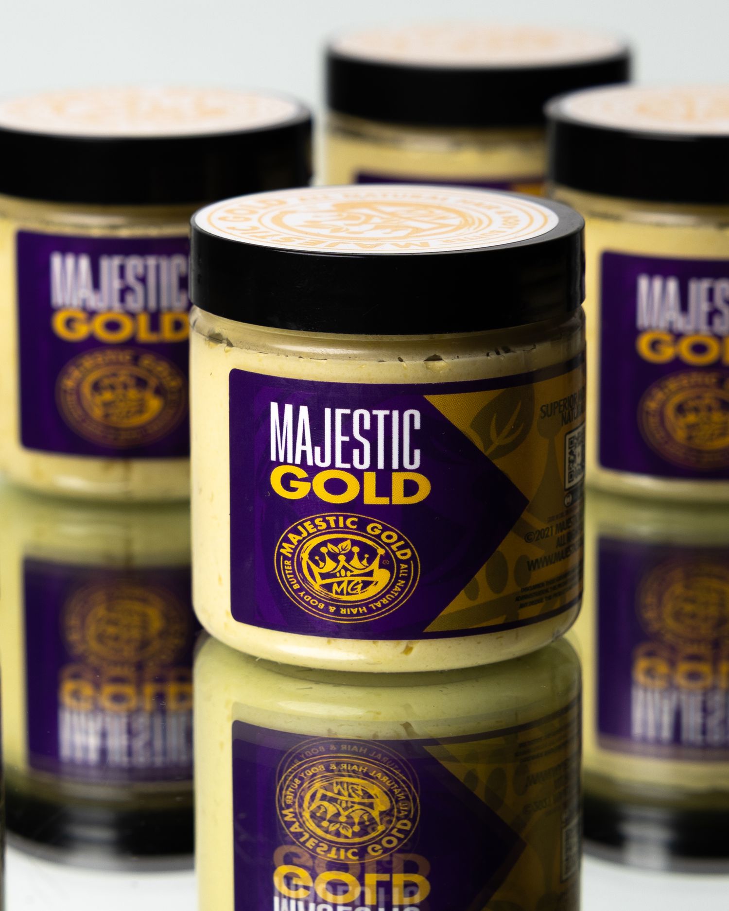 Majestic Gold brand product containers lined up showing purple and gold packaging design.