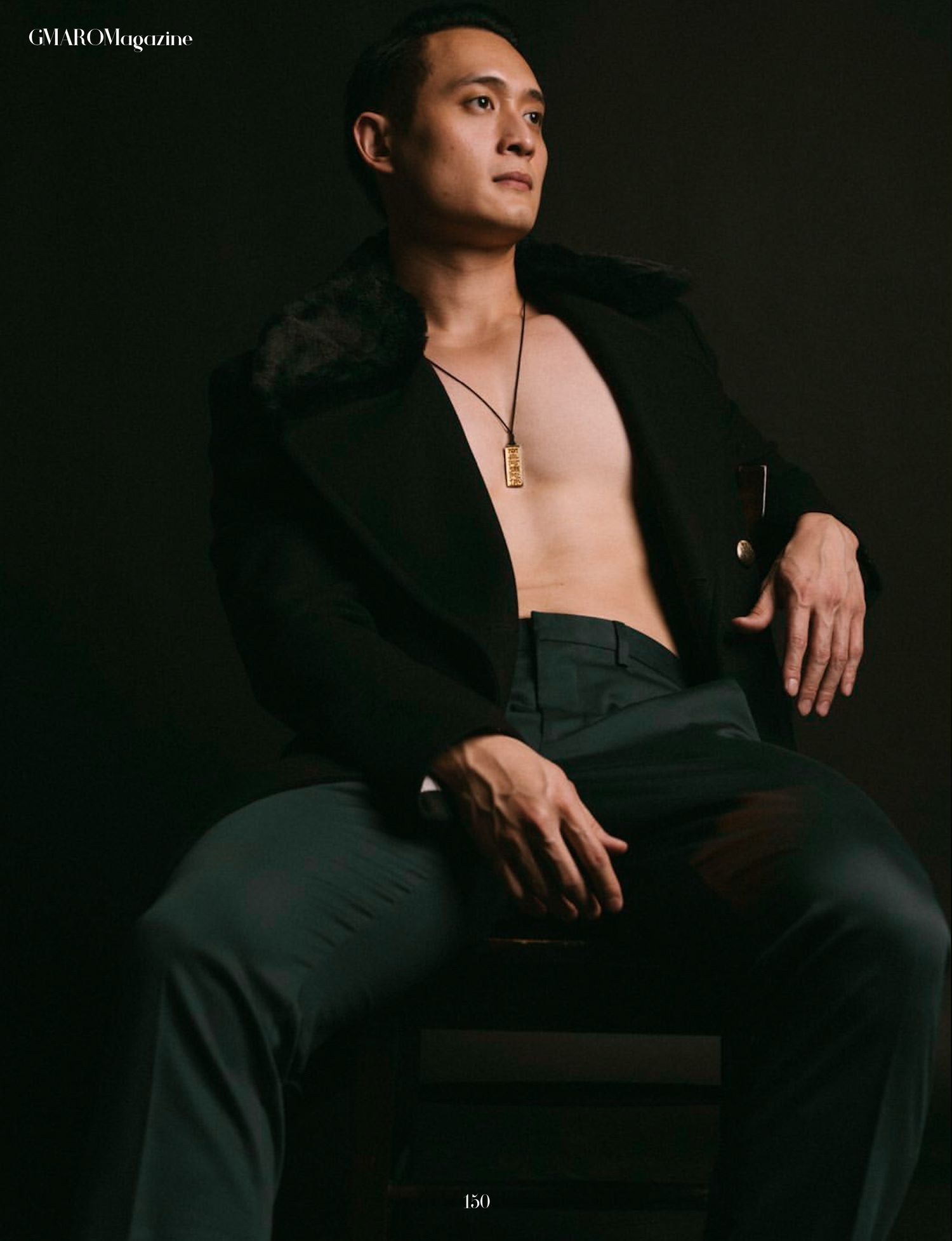 Dramatic fashion photo showing model in open black jacket against dark background.