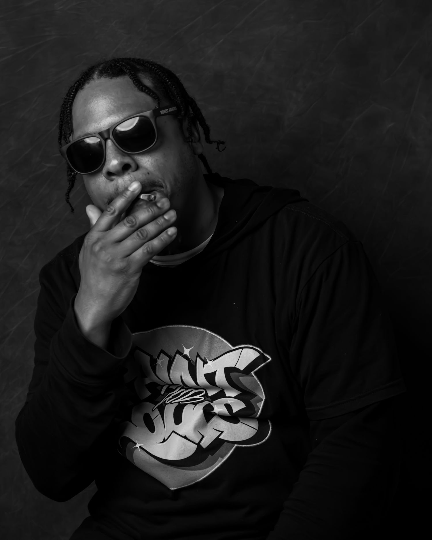 Dark contrast photos showing figure in streetwear with smoke effects.