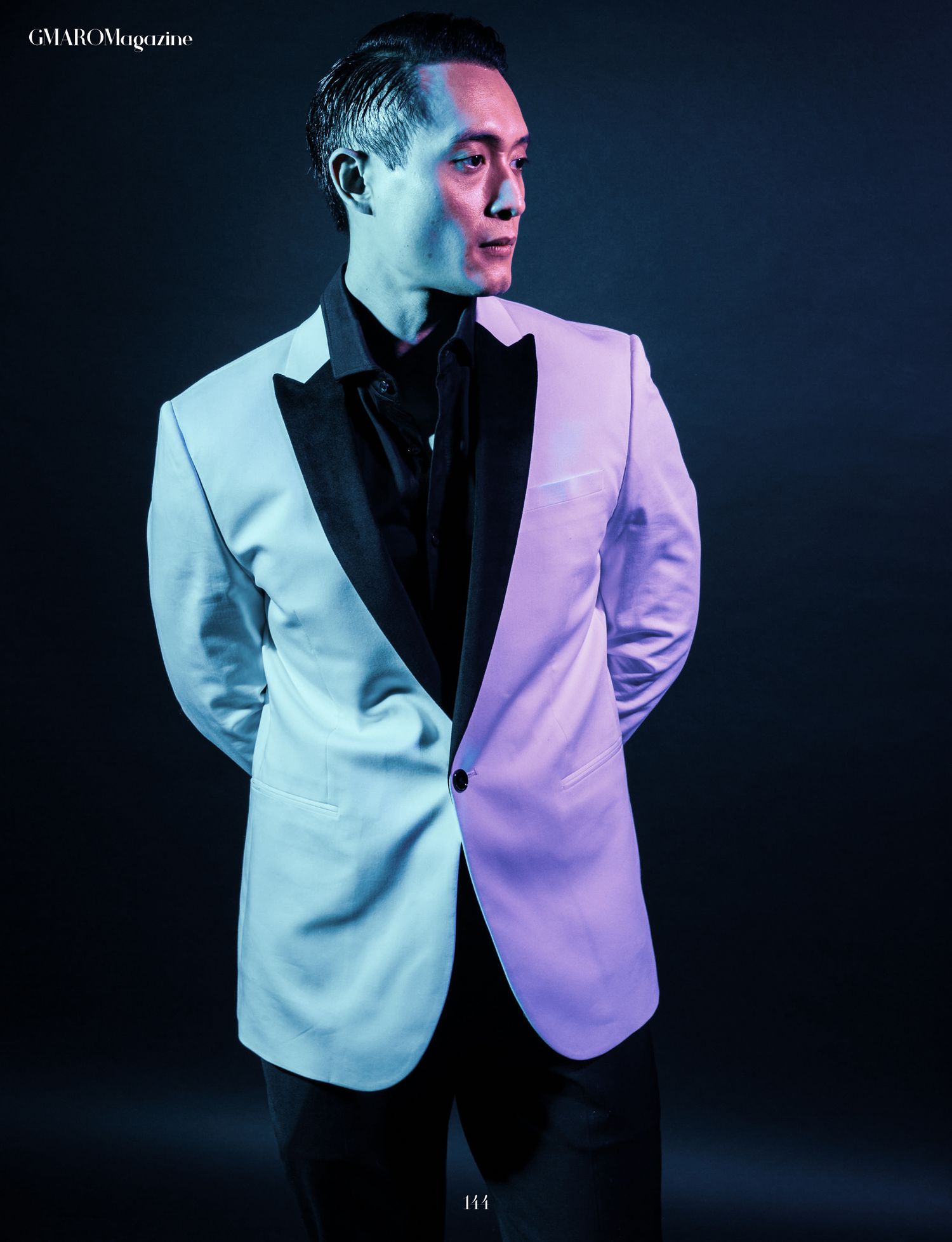 Fashion editorial with split lighting showing white blazer against dark background.