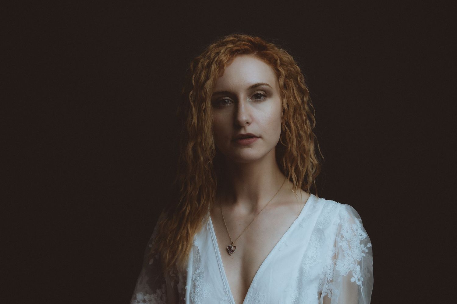 Artistic portrait series with vintage-inspired white lace dress against dark background.