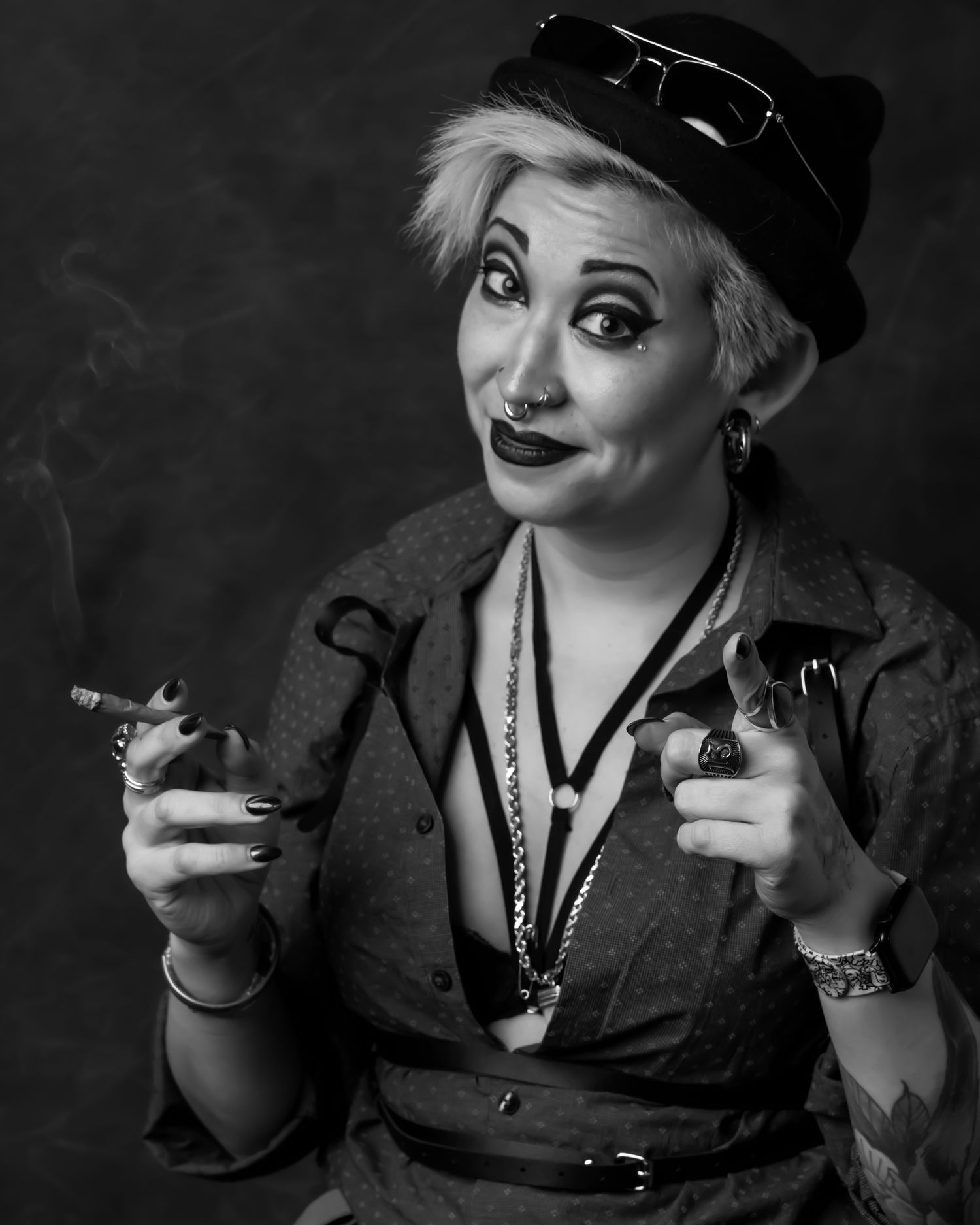 Vintage-style portrait of someone in hat and dramatic makeup holding a cigarette.