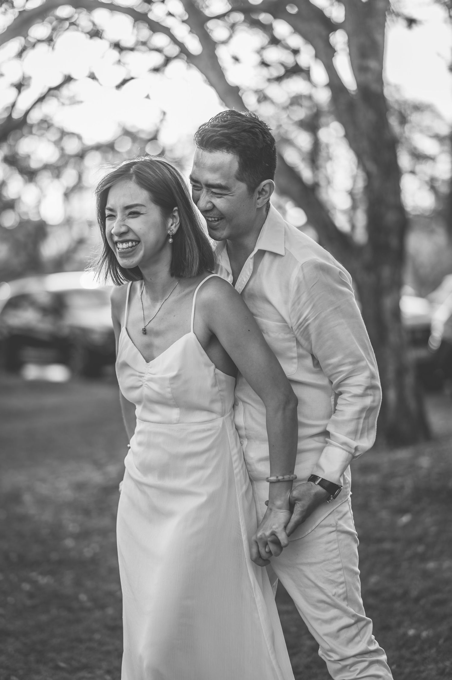 Black and white sequence of a romantic dance in white attire outdoors.