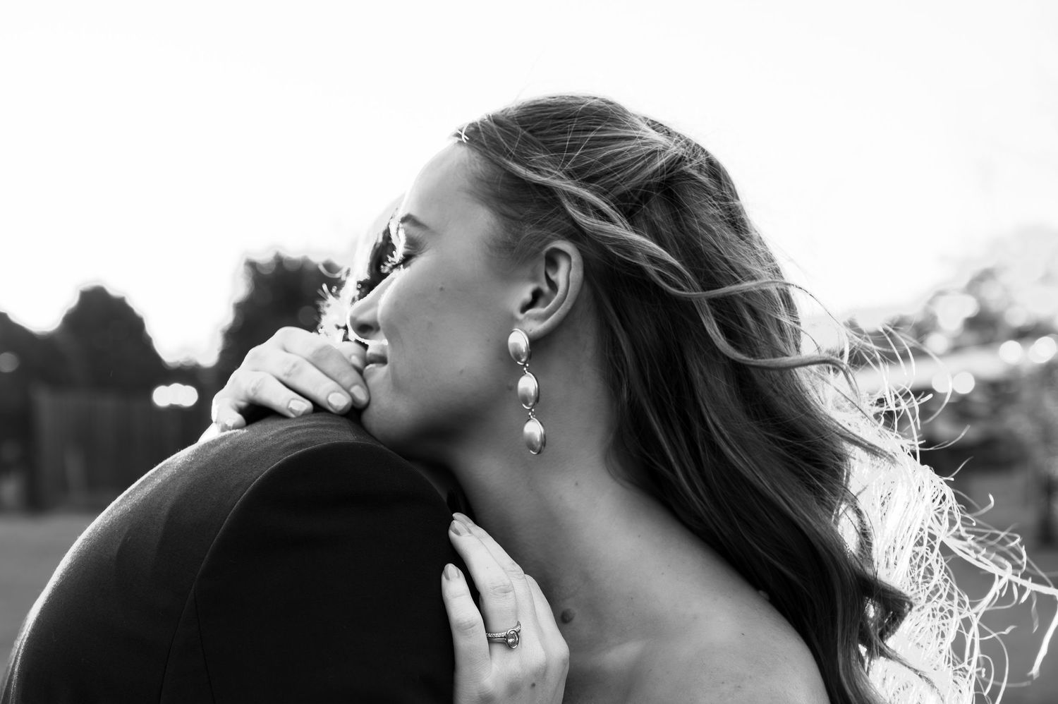 Bride and groom share an intimate moment in black and white wedding photography with natural outdoor lighting.