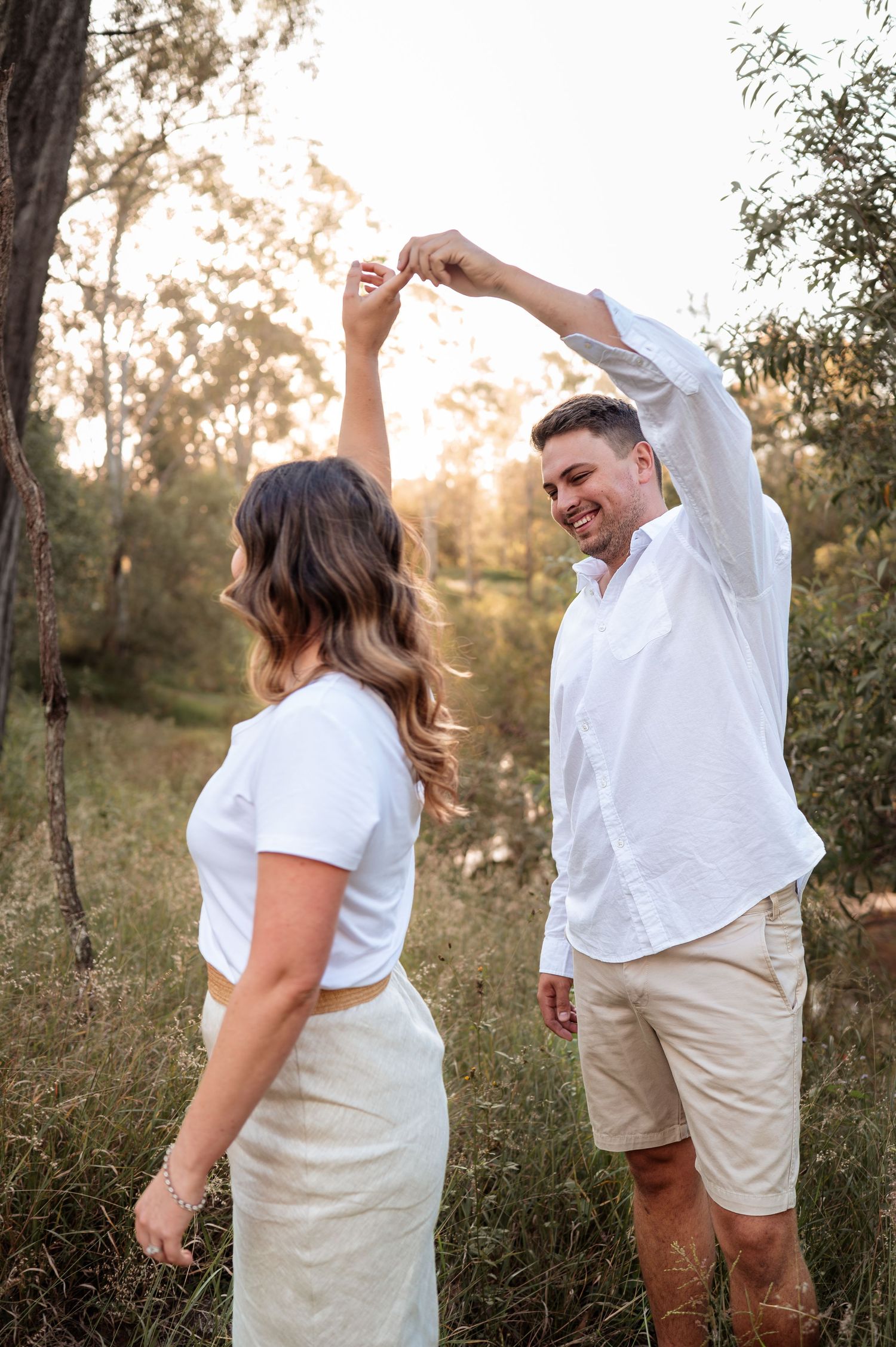 Sequence of dancing and twirling in white outfits against a sunset woodland backdrop.