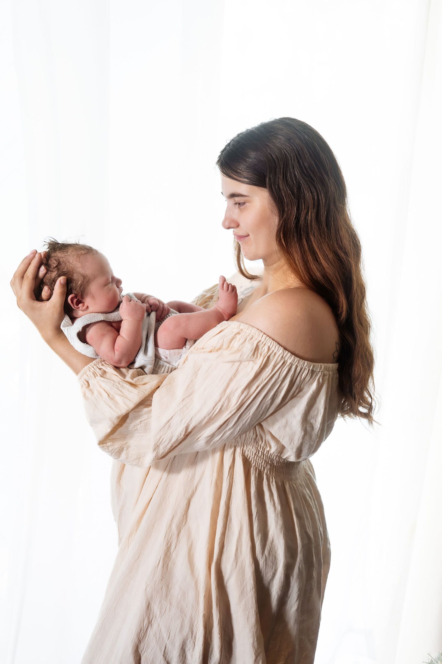 Artistic progression photos of mother holding newborn against white background.