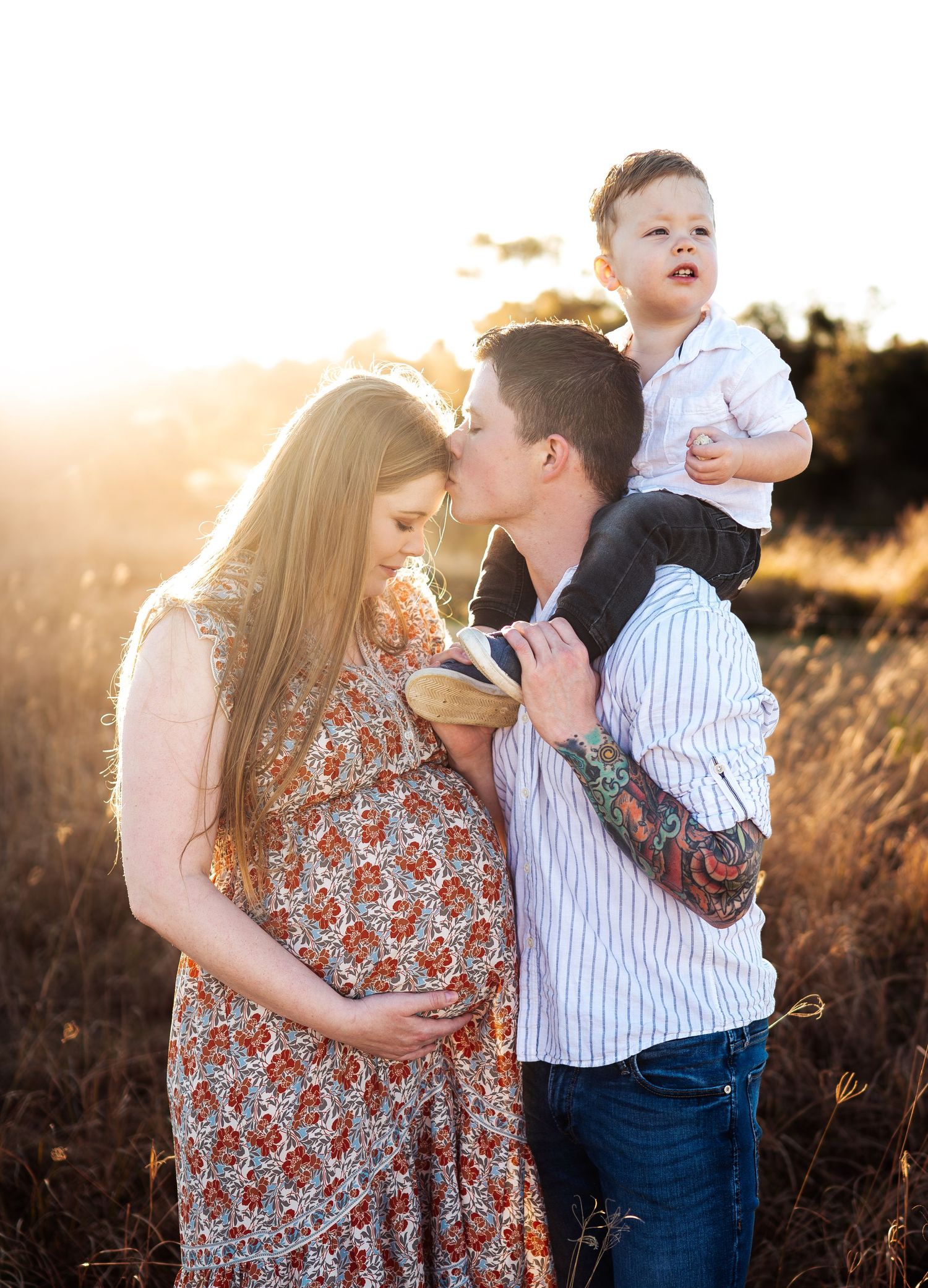 Family portrait session in field during golden hour with playful poses.