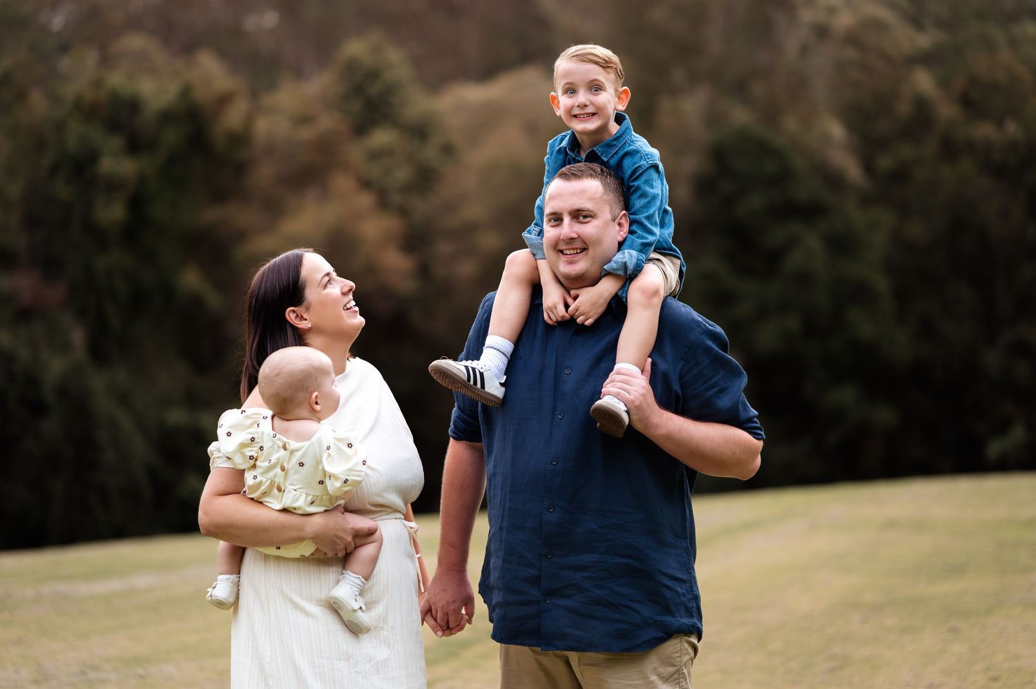 Progressive shots of family members playing and laughing together on a grassy hillside.