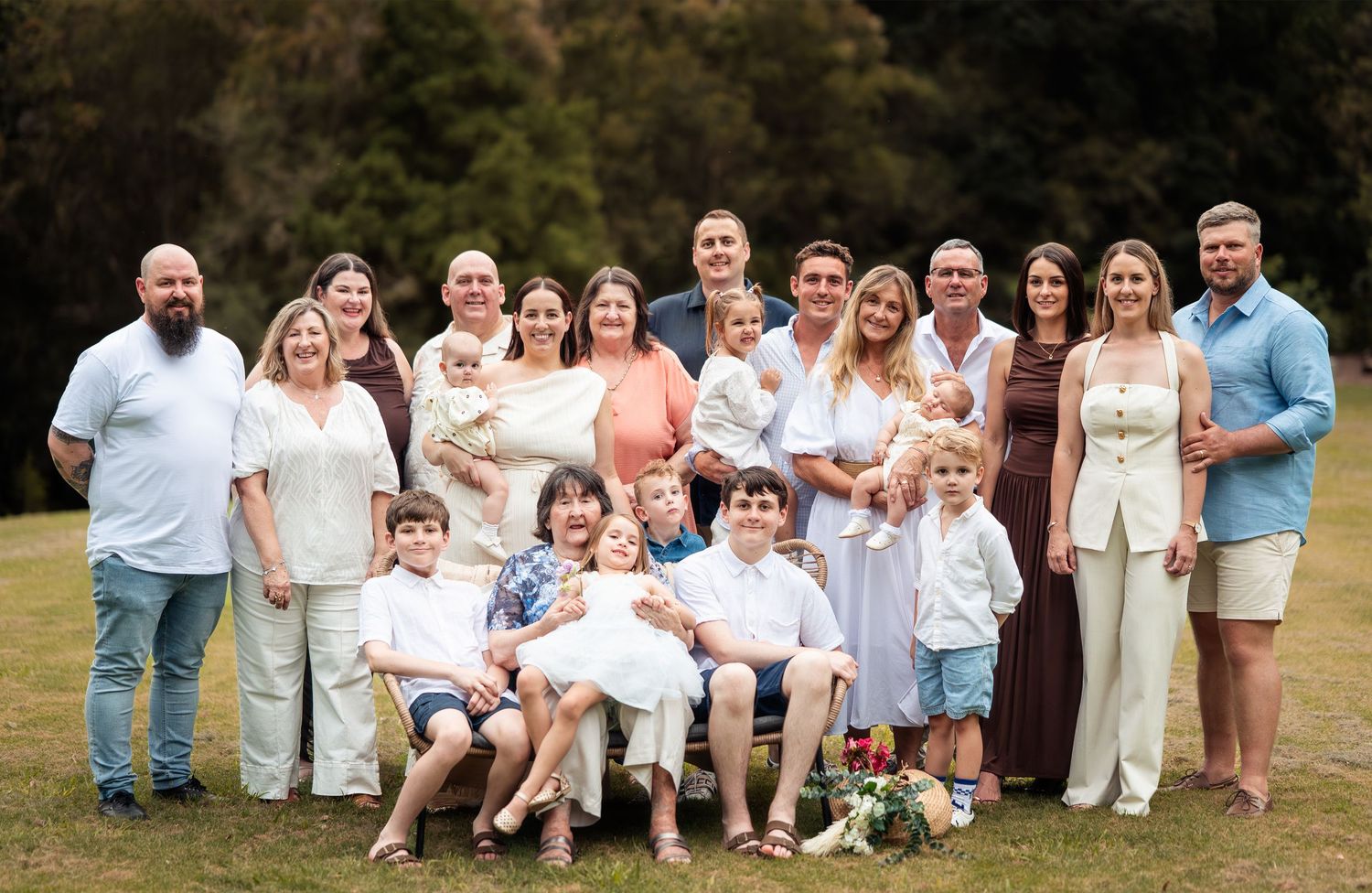 Extended family portrait session outdoors with coordinated white and neutral clothing.
