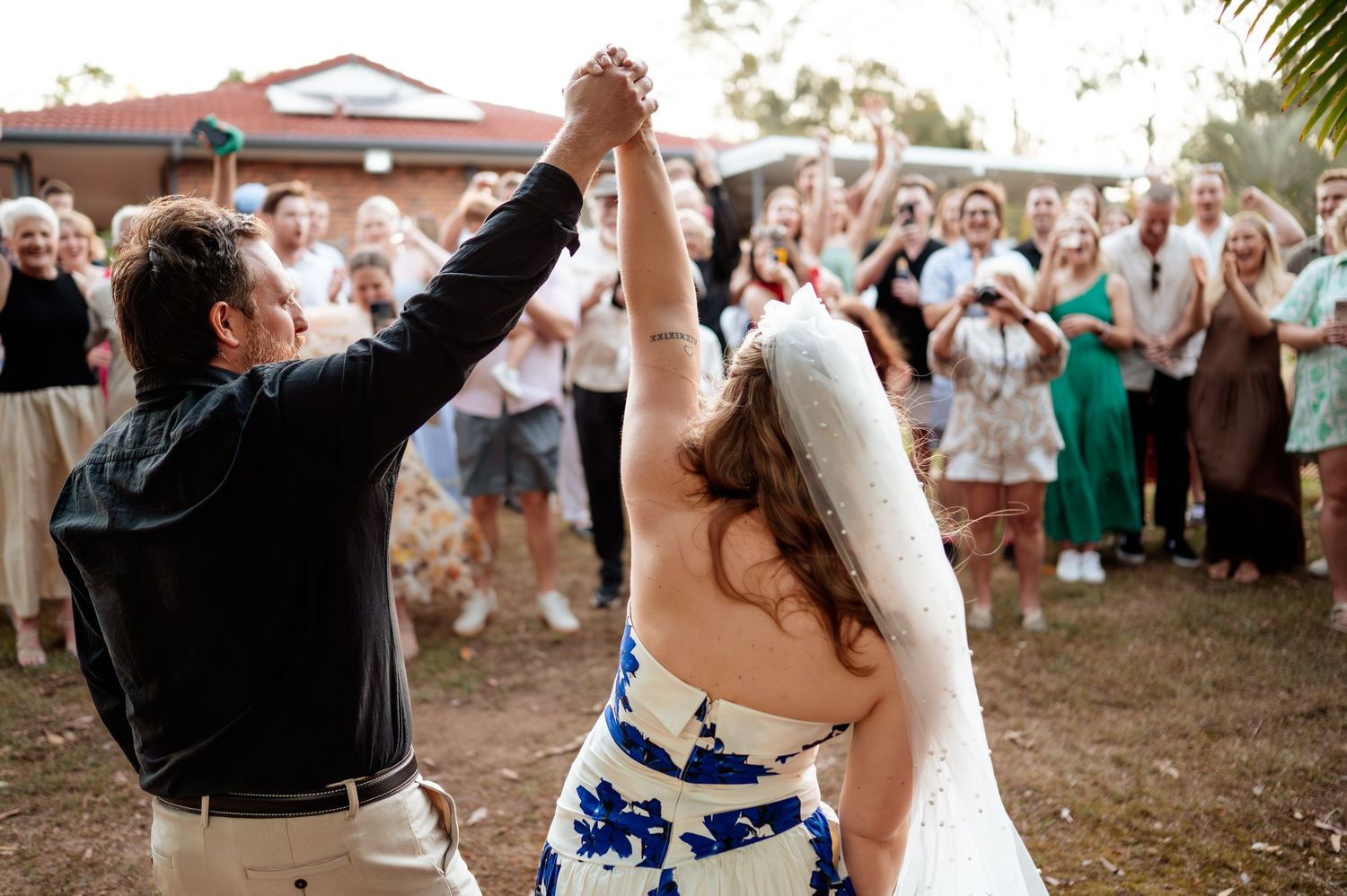 Wedding guests celebrate and dance together during an outdoor reception celebration.