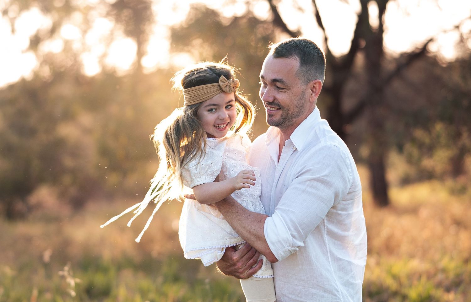Sweet family embraces captured during sunset in a natural outdoor setting.