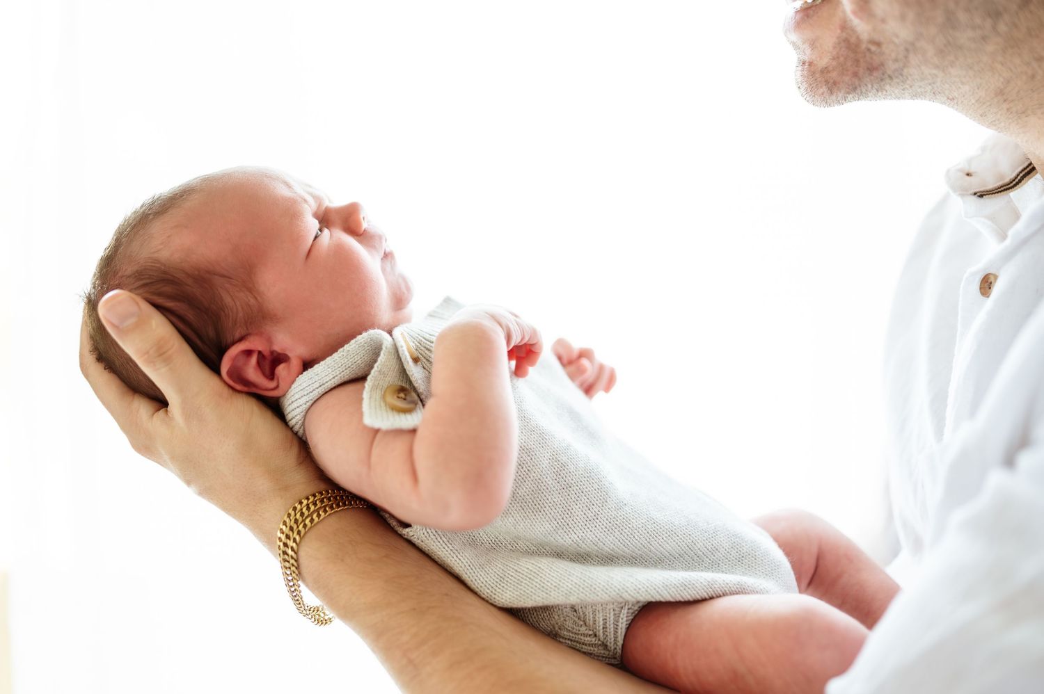 Series of gentle moments between parent and newborn in soft natural lighting.