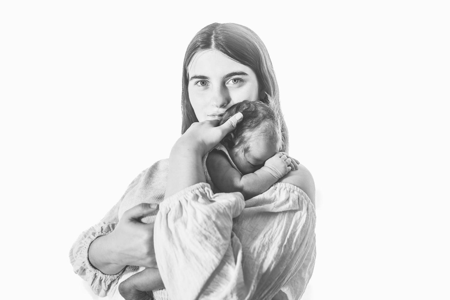 Black and white portrait series showing tender moments between parent and newborn.