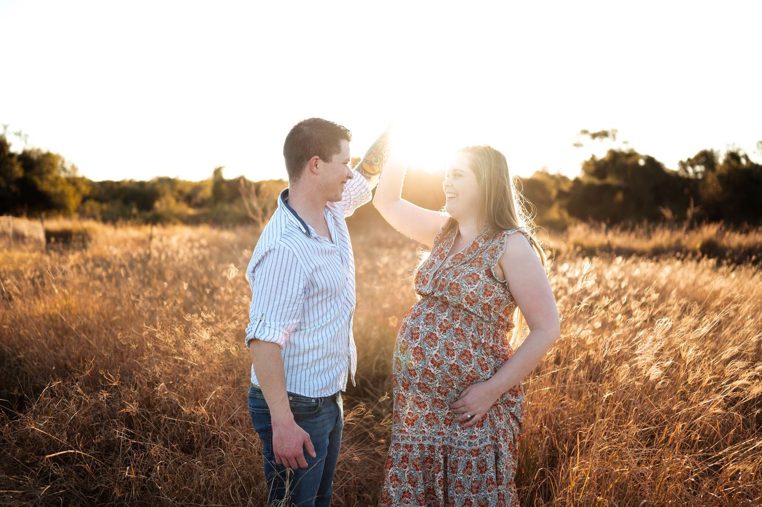 Family silhouetted against glowing sunset in rustic outdoor setting.