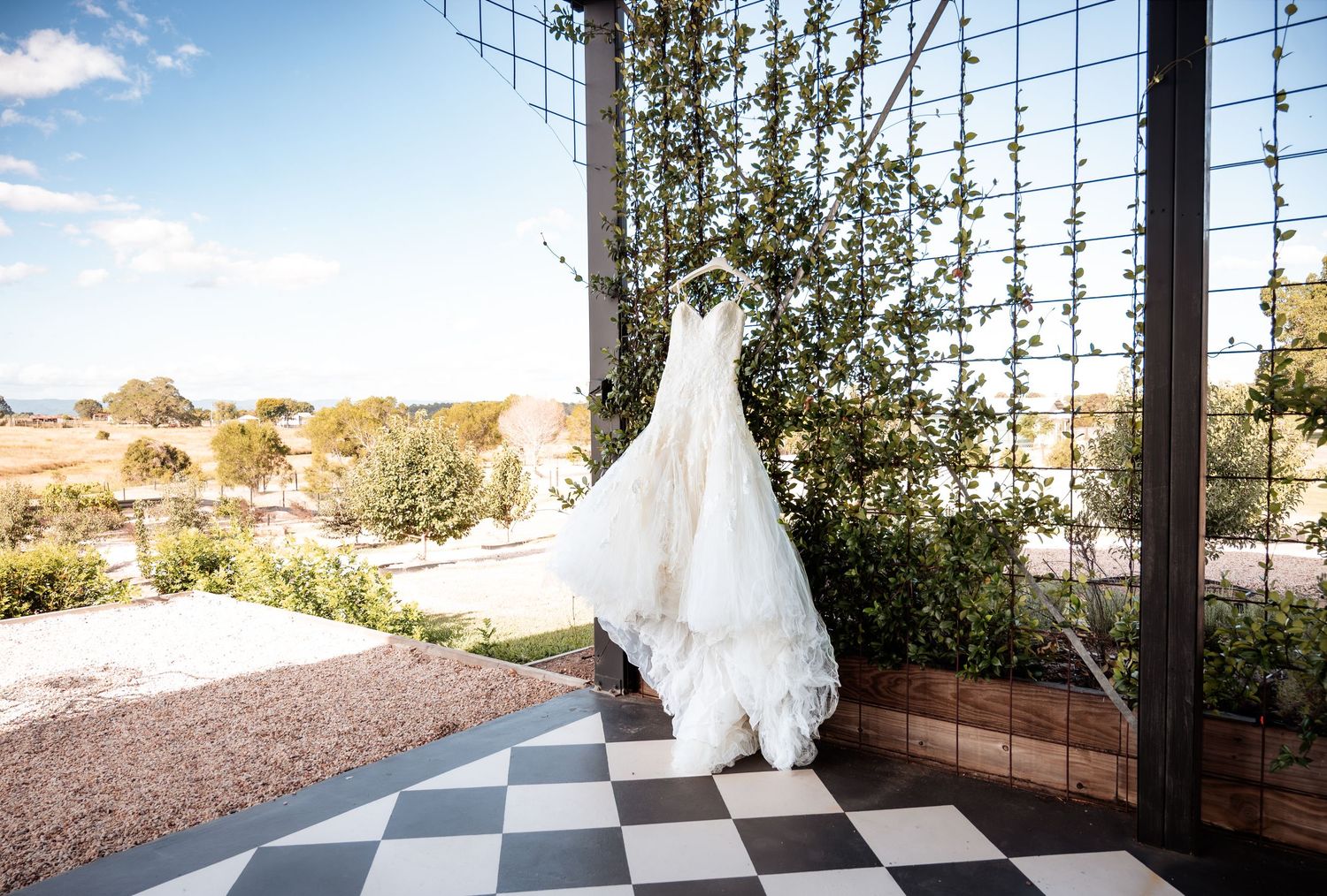 Elegant wedding dress silhouettes against a modern architectural backdrop with mountain views.