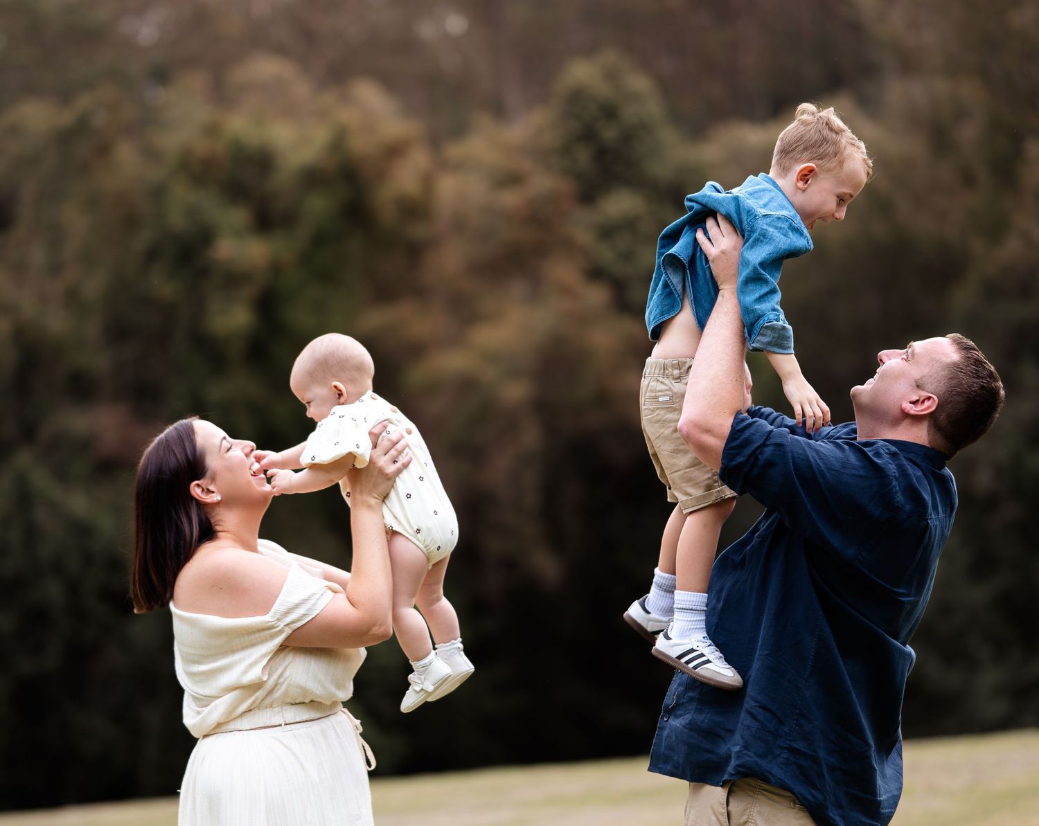 A joyful outdoor photo sequence showing a couple lifting and playing with a baby in a grassy field.