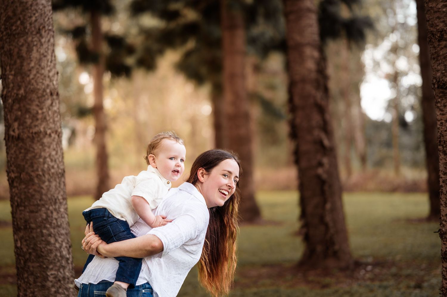 Candid family moments captured in a forest setting with natural lighting.