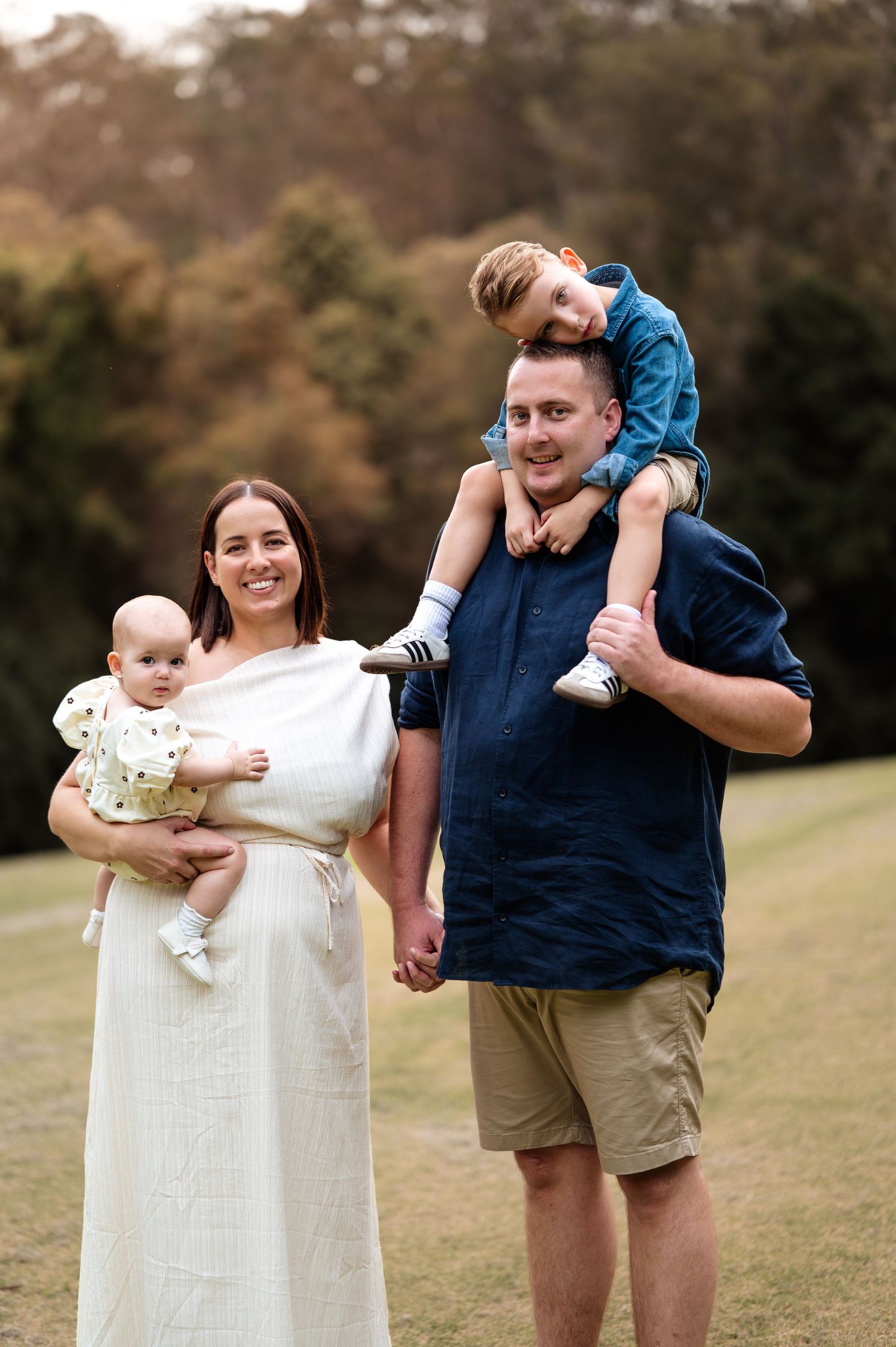 Candid outdoor family portraits showing playful interactions in a natural setting.