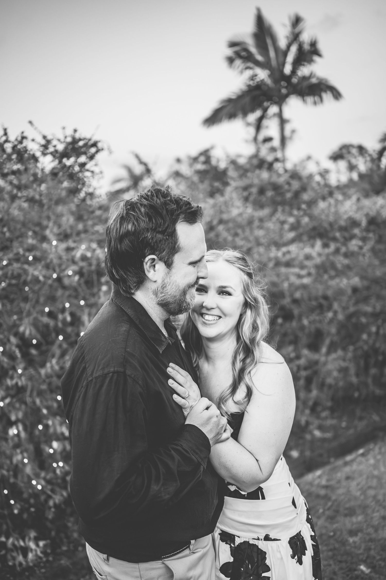 An intimate black and white portrait of a couple sharing a romantic moment.