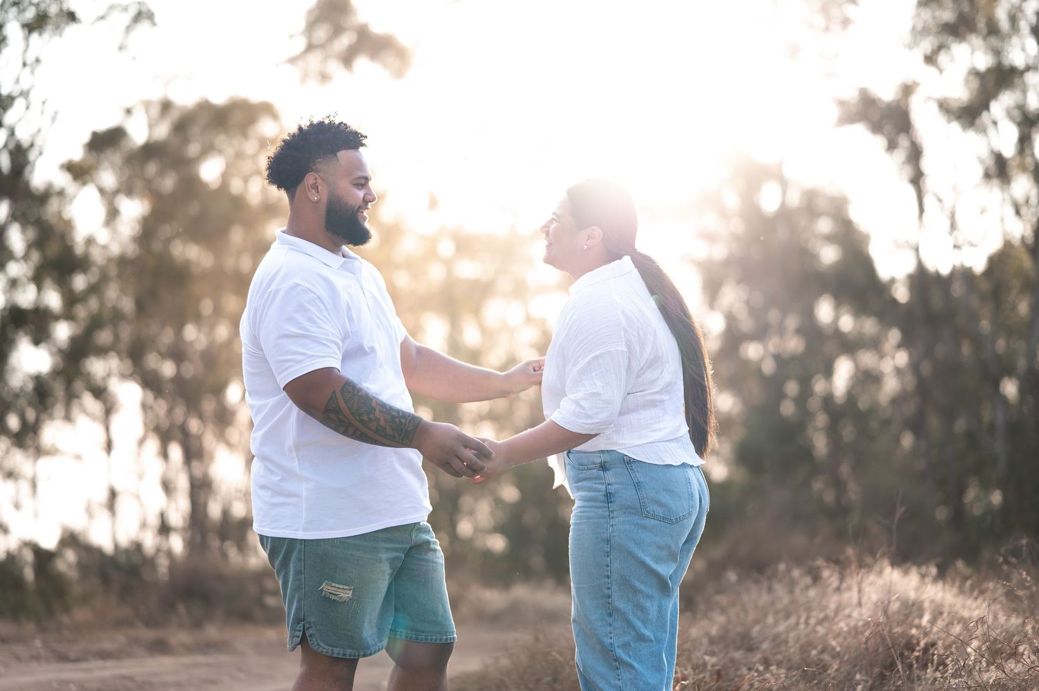 Two people share a joyful conversation in an outdoor setting at sunset.