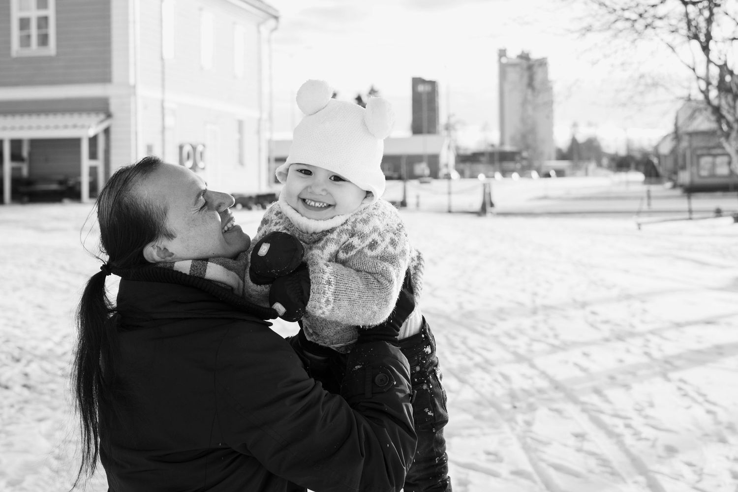 Mies pitää poikaa ja hymyilee.