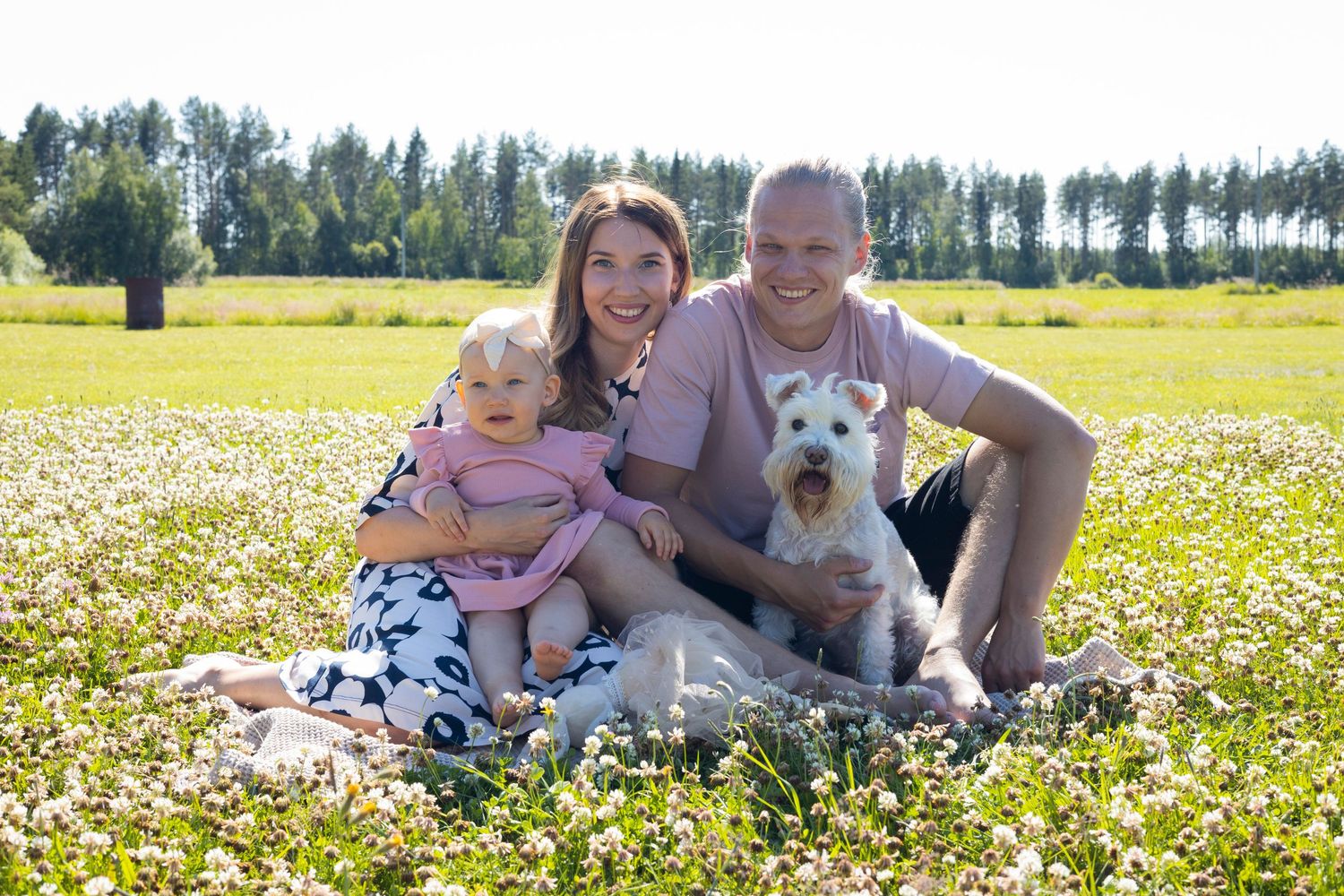 Perhe ja koira katsoo eteenpäin ja hymyilee Raahessa.