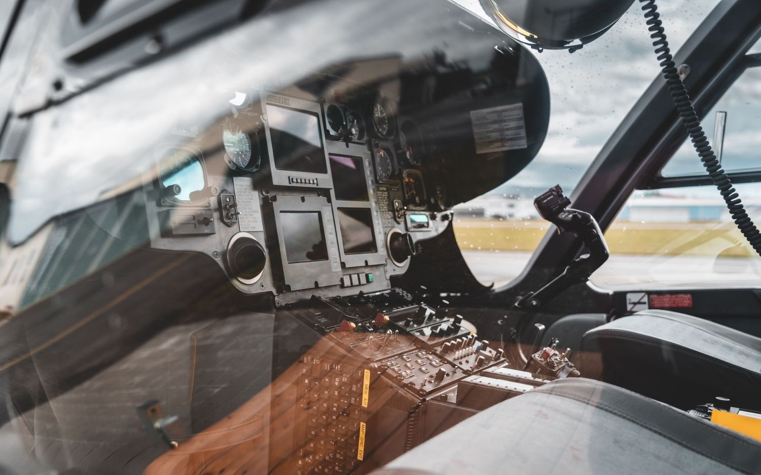 Detailed view of helicopter cockpit interior showing flight instruments, controls, and navigation equipment.