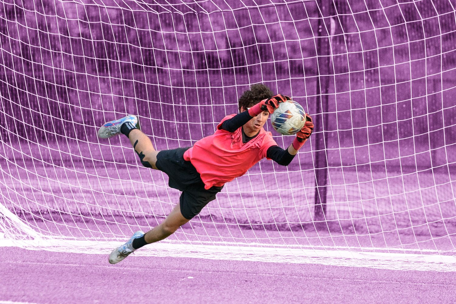 High school soccer goalkeeper making a diving save in Southeastern Massachusetts
