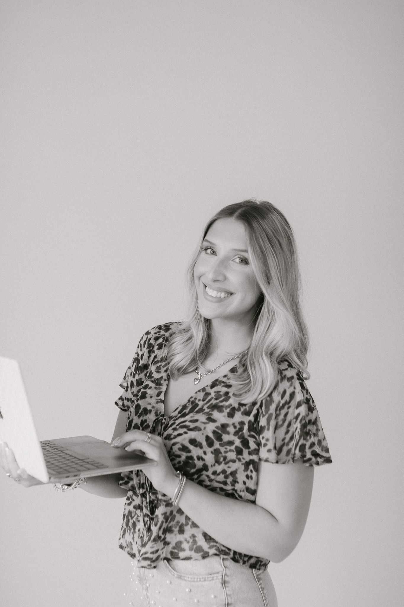 A client of Saylor Heirloom Photography in a professional branding session holding their computer smiling.