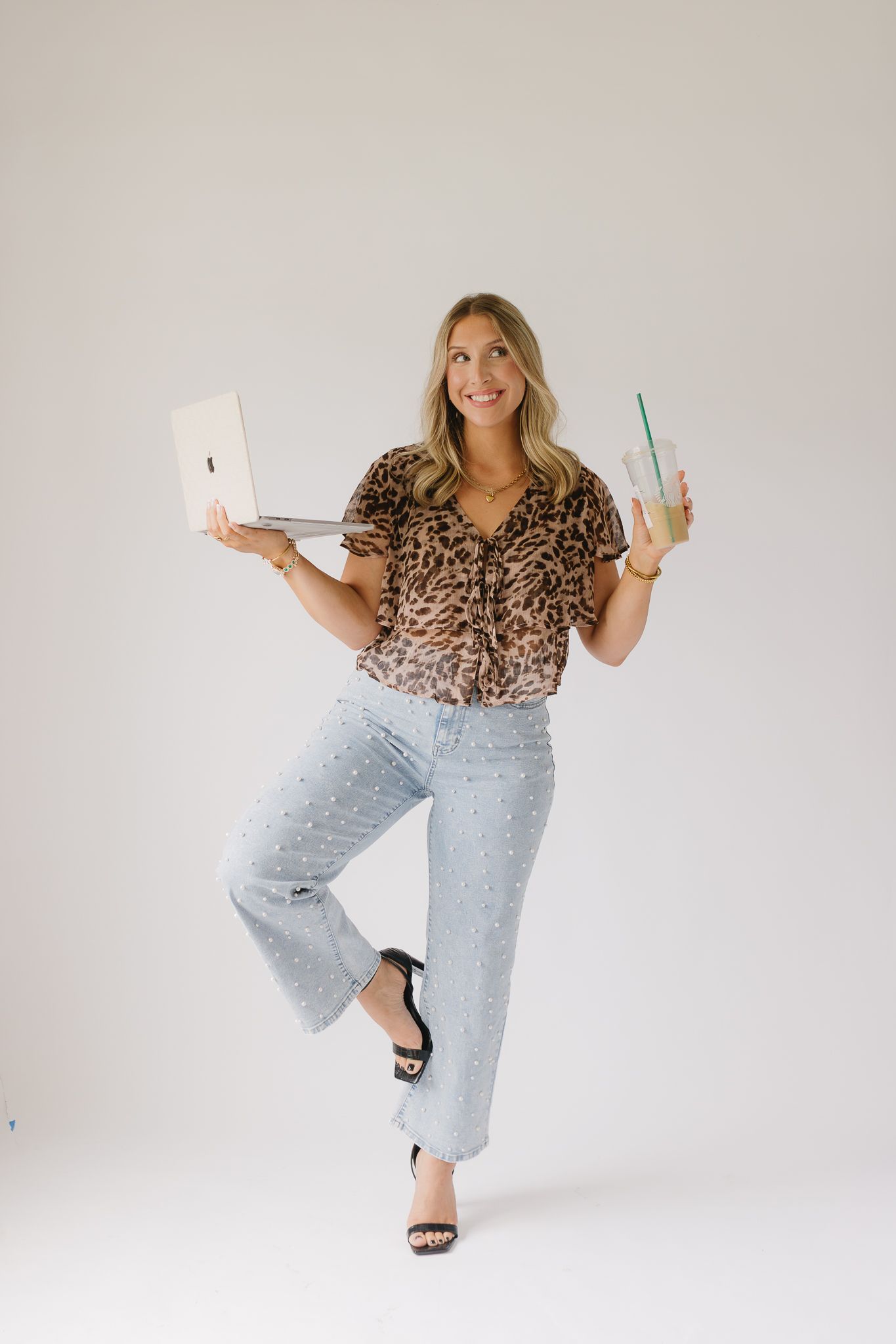 A client of Saylor Heirloom Photography in a professional branding session holding a coffee and computer representing their fun aesthetic.