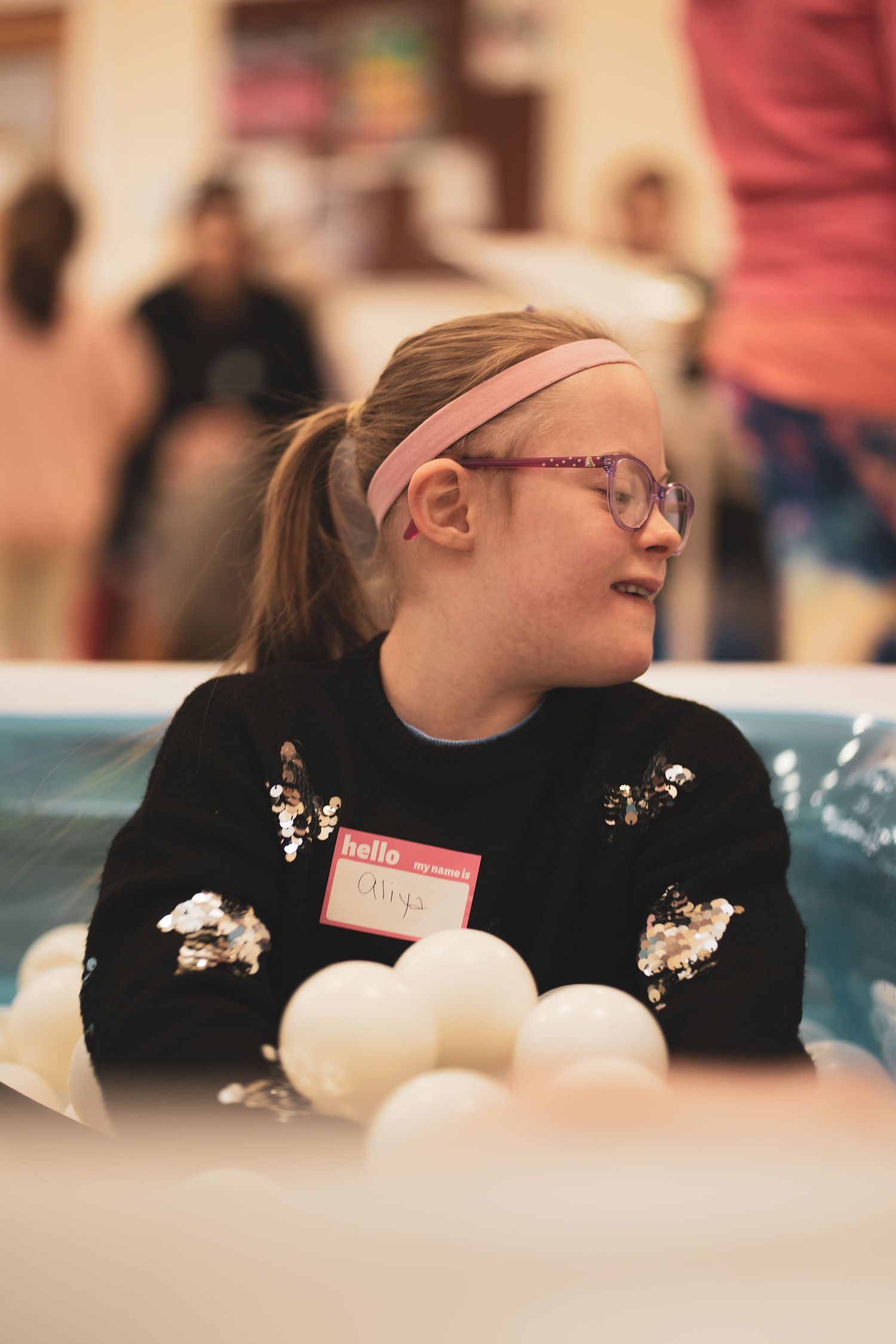 A child wearing glasses smiling at a table with white eggs in front of them.