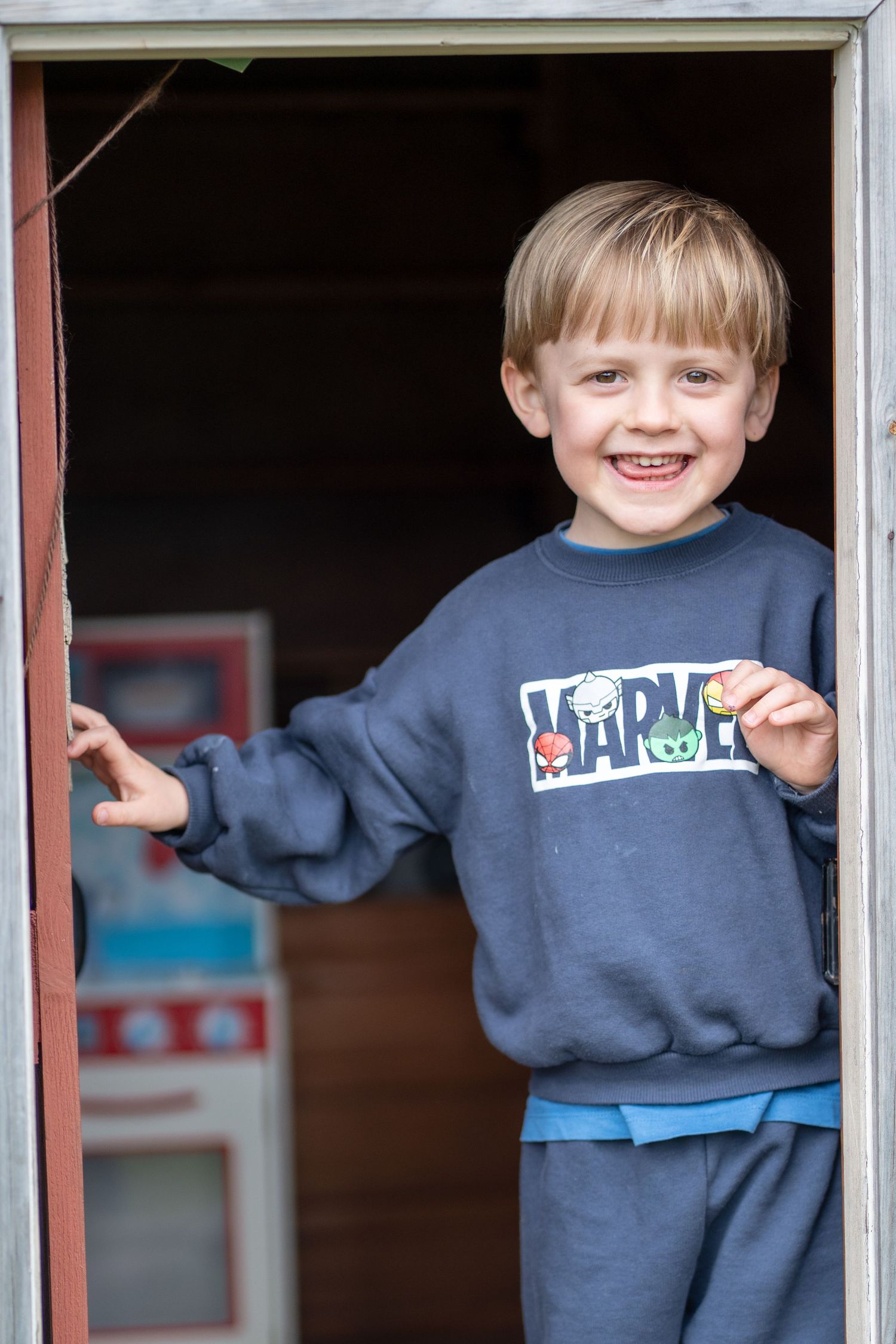 A smiling child standing in an open doorway.