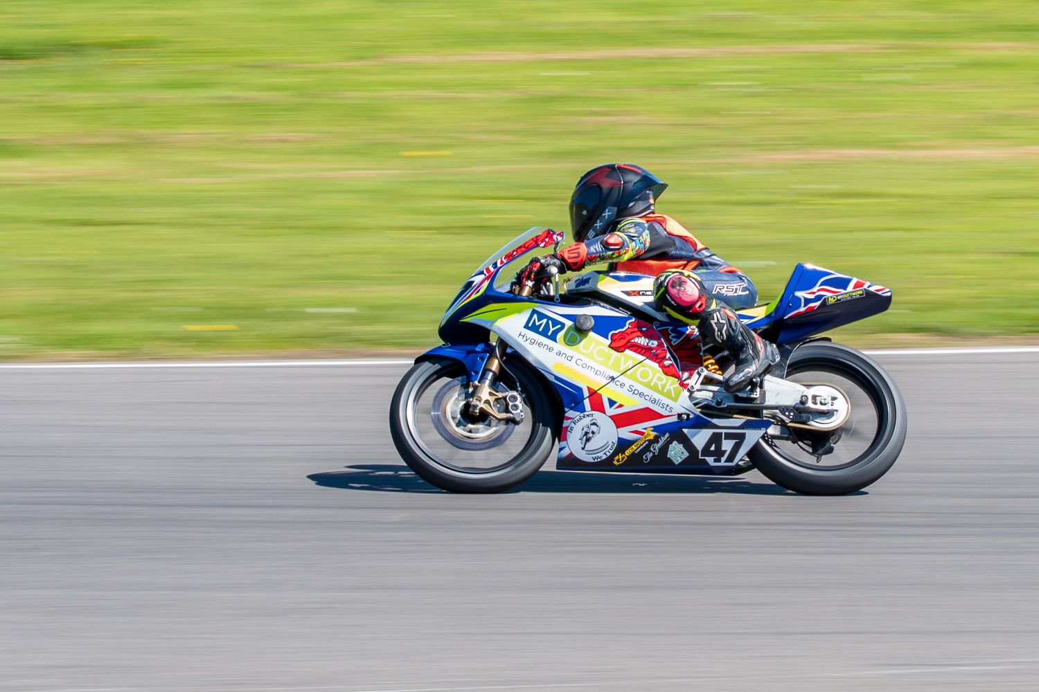 Colorful Red Bull sponsored racing motorcycle number 47 on a race track.