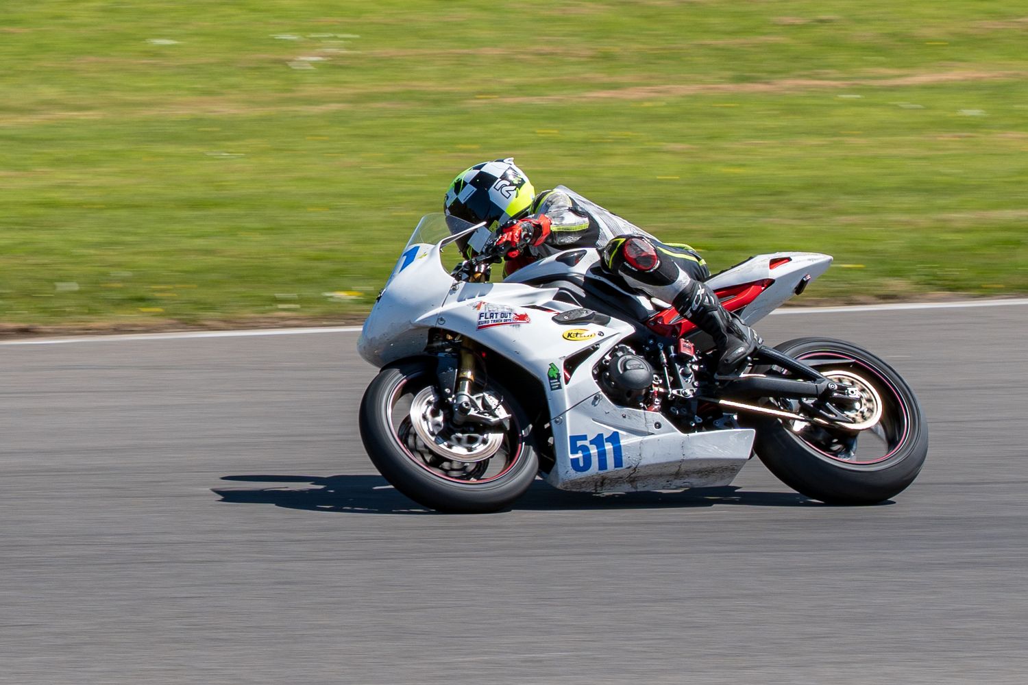 White racing motorcycle number 511 speeding along a professional race circuit.
