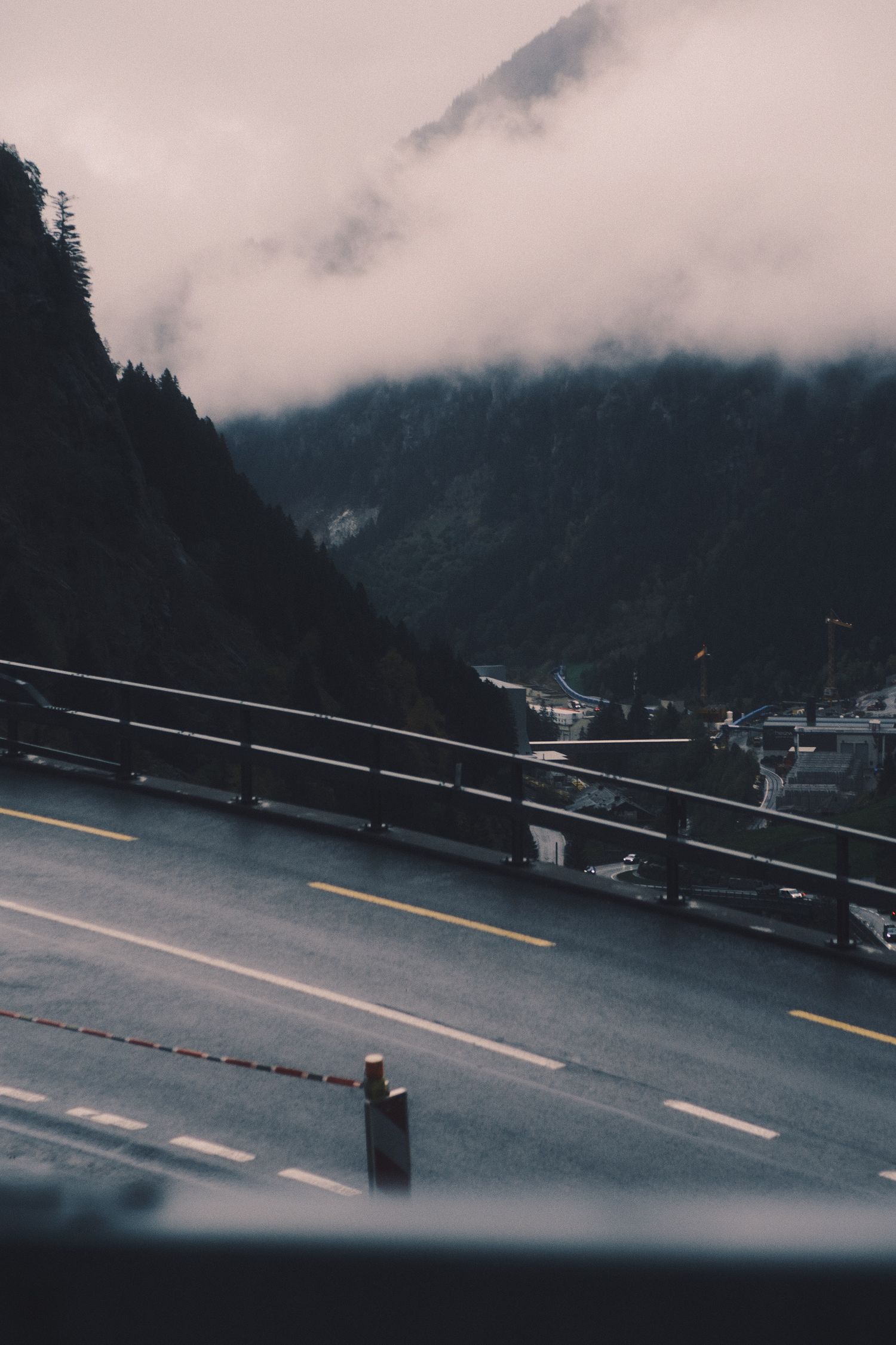 Wet mountain road and guardrail under low cloud on the Gotthard Pass, Switzerland