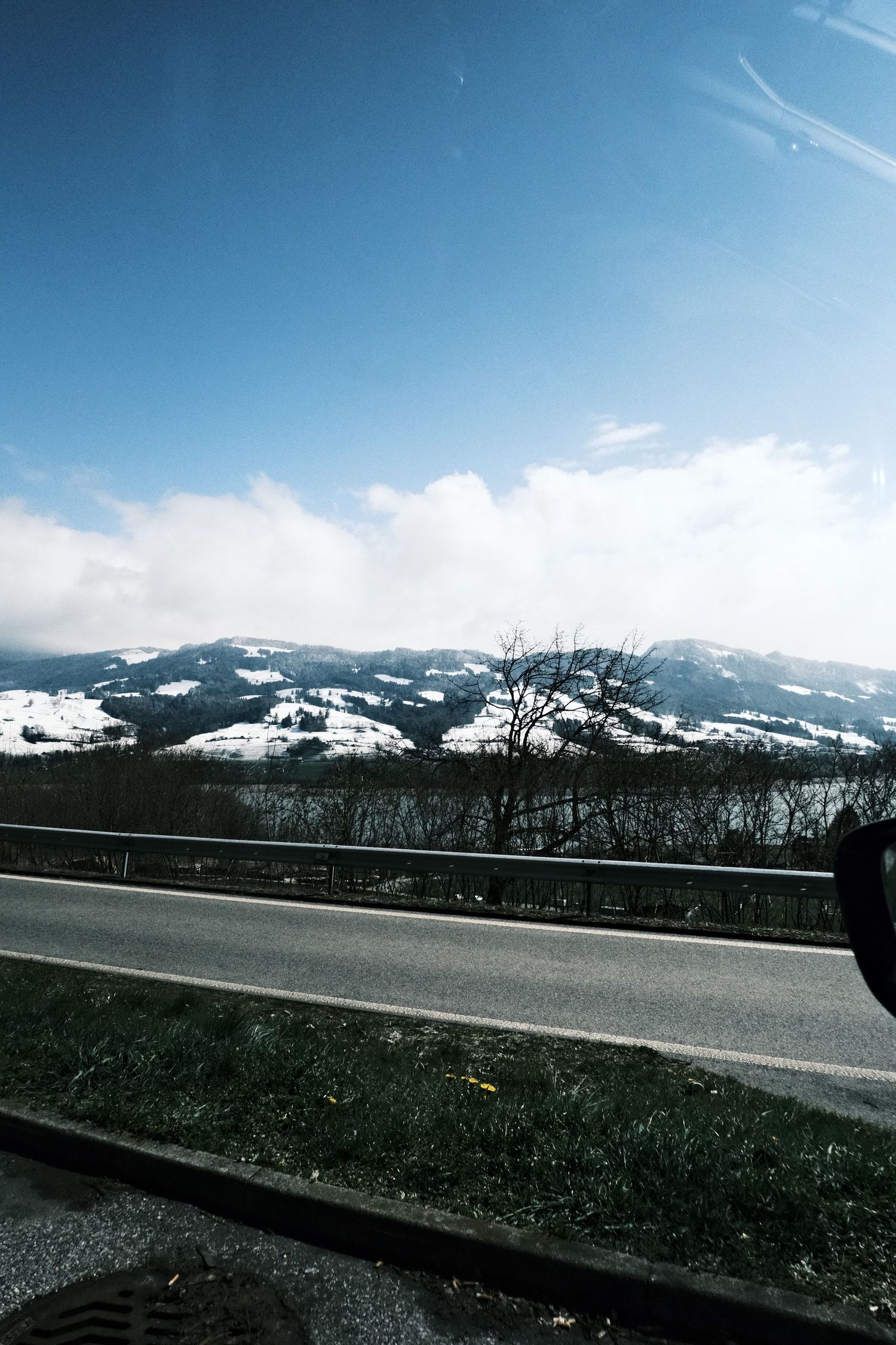 Empty road over the Gotthard Pass with snow-covered Alpine peaks in the distance